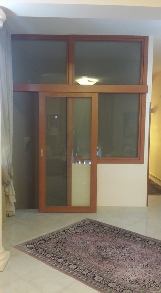 Una stanza con una porta scorrevole in vetro e un tappeto.