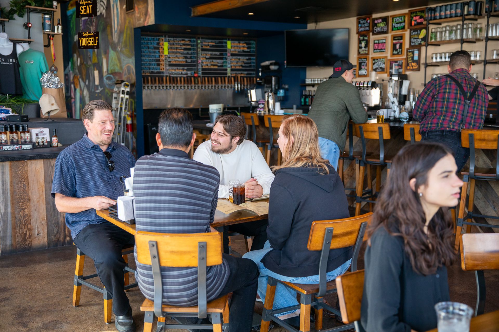 A group of people are sitting at tables in a restaurant.