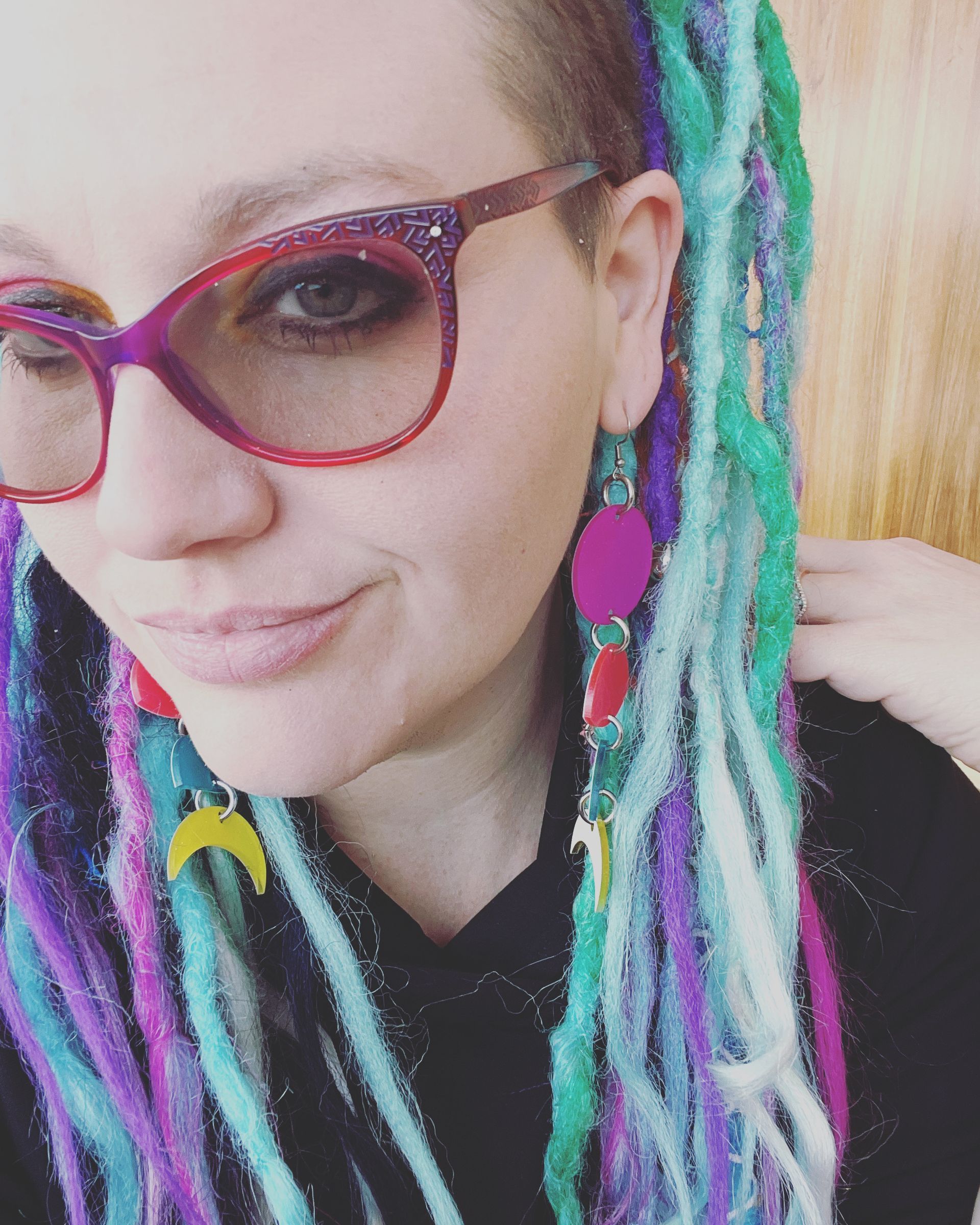 A woman with dreadlocks wearing glasses and earrings