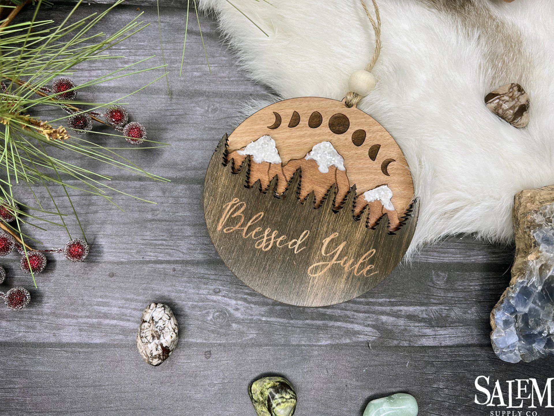 A wooden ornament with mountains on it is sitting on a wooden table.