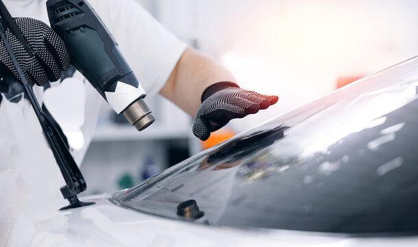 Person Heating up some ceramic tint on the car 