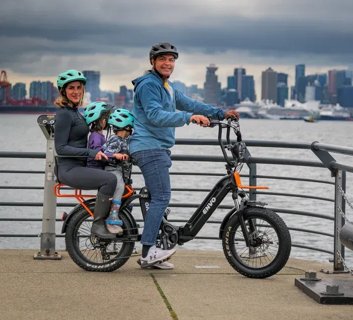 A woman is standing next to a red ebike in the grass in Ottawa.