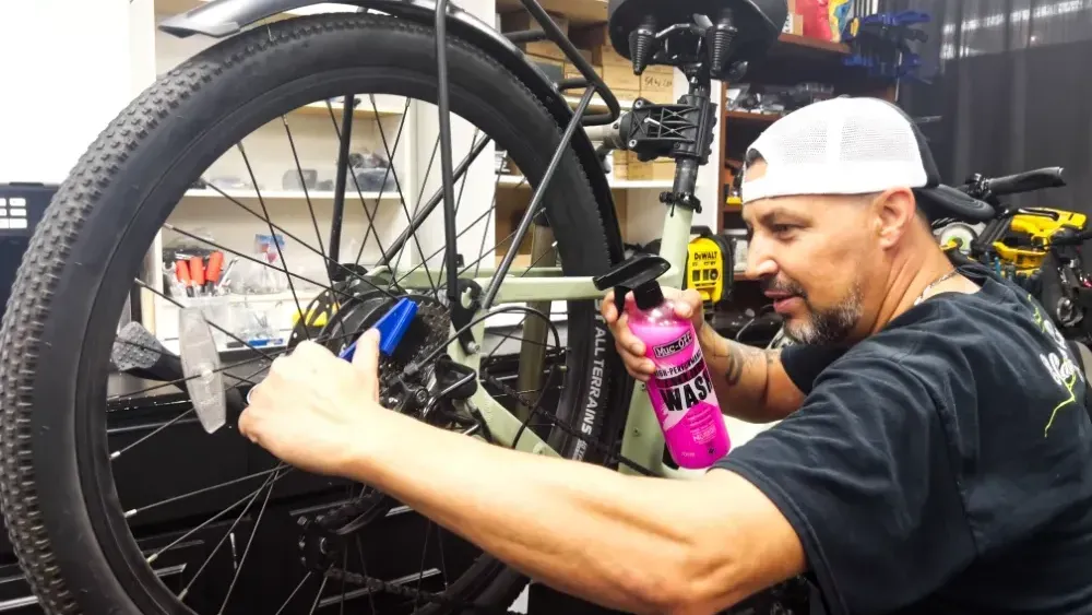 A man is riding an electric bike on a dirt road in the woods.