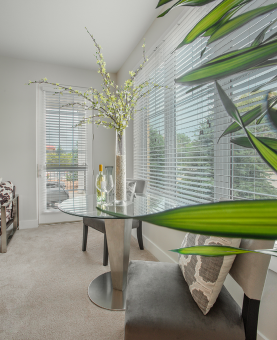 A living room with a glass table and chairs