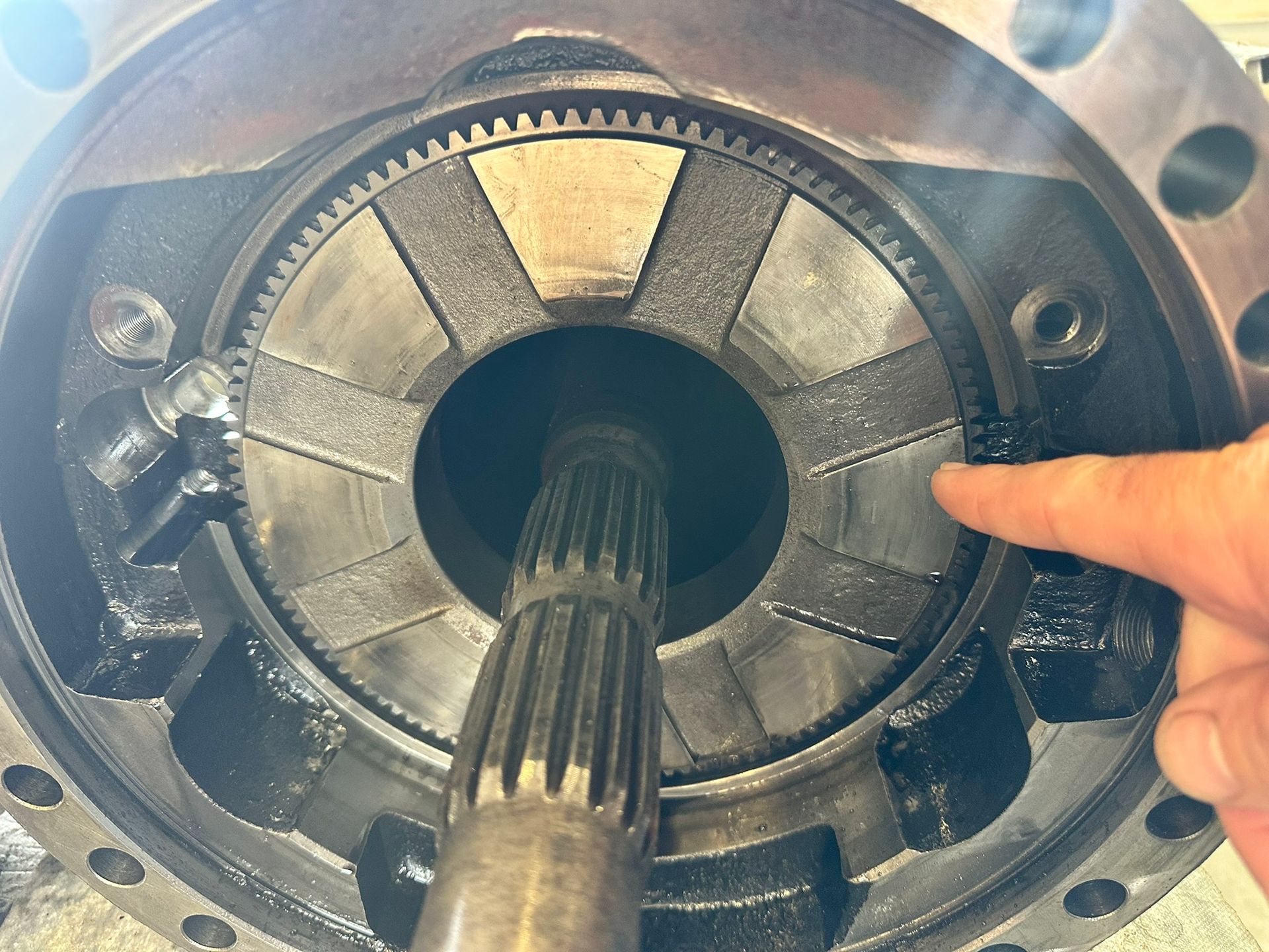 Open differential gear assembly with a finger pointing to a clutch plate.