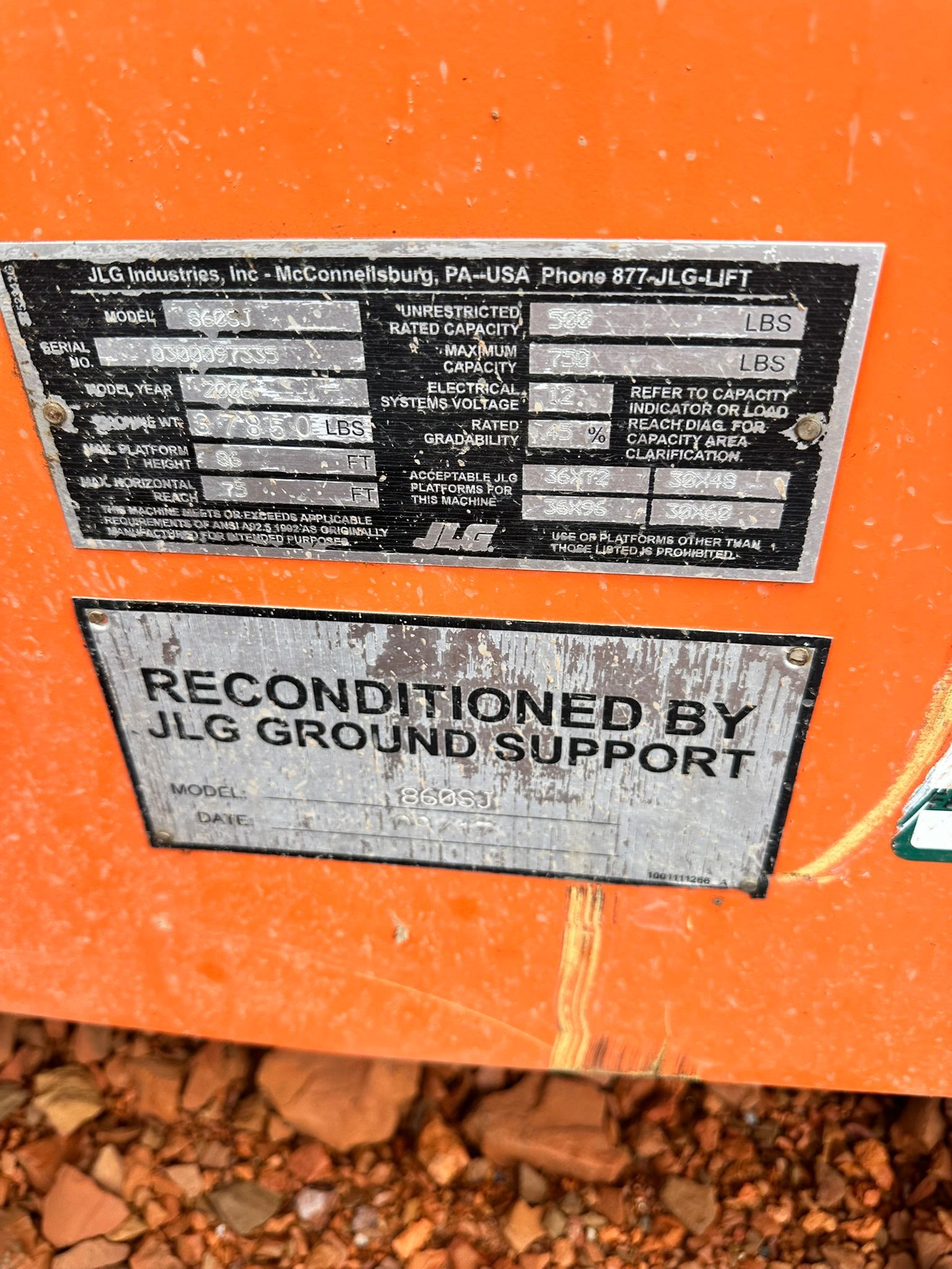 Orange equipment with two metal plates, machine's information, and one saying 