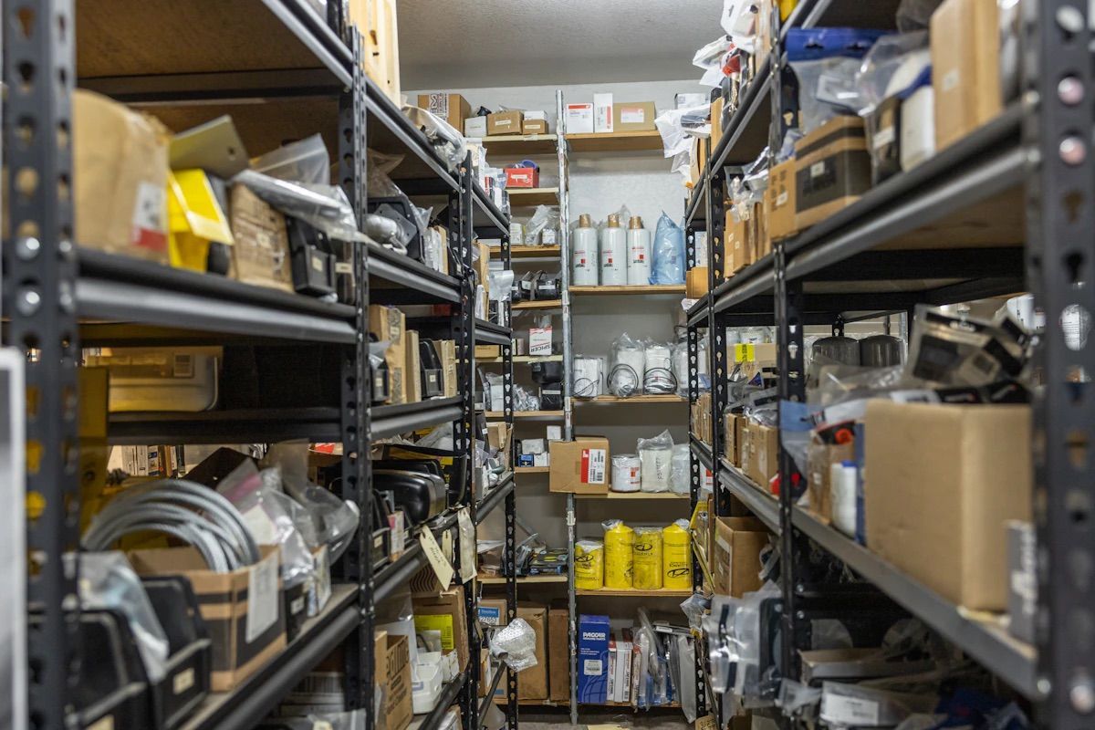 Shelves filled with various boxes, containers, and supplies in a storage room.