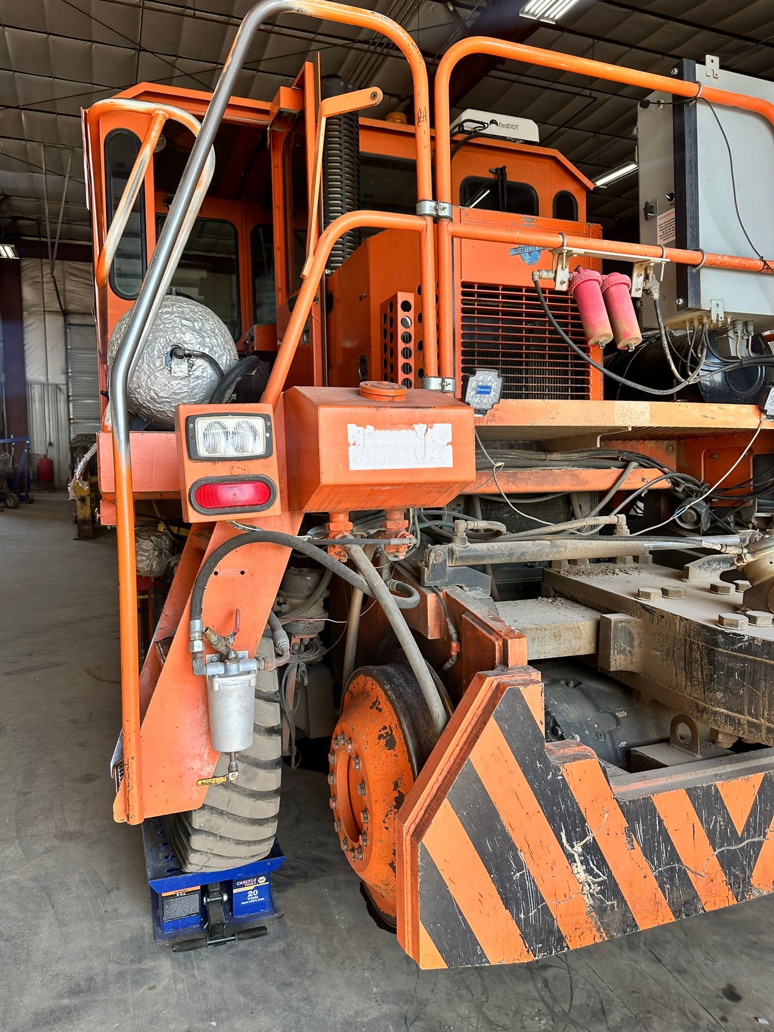 Orange and black railway maintenance vehicle on tracks.