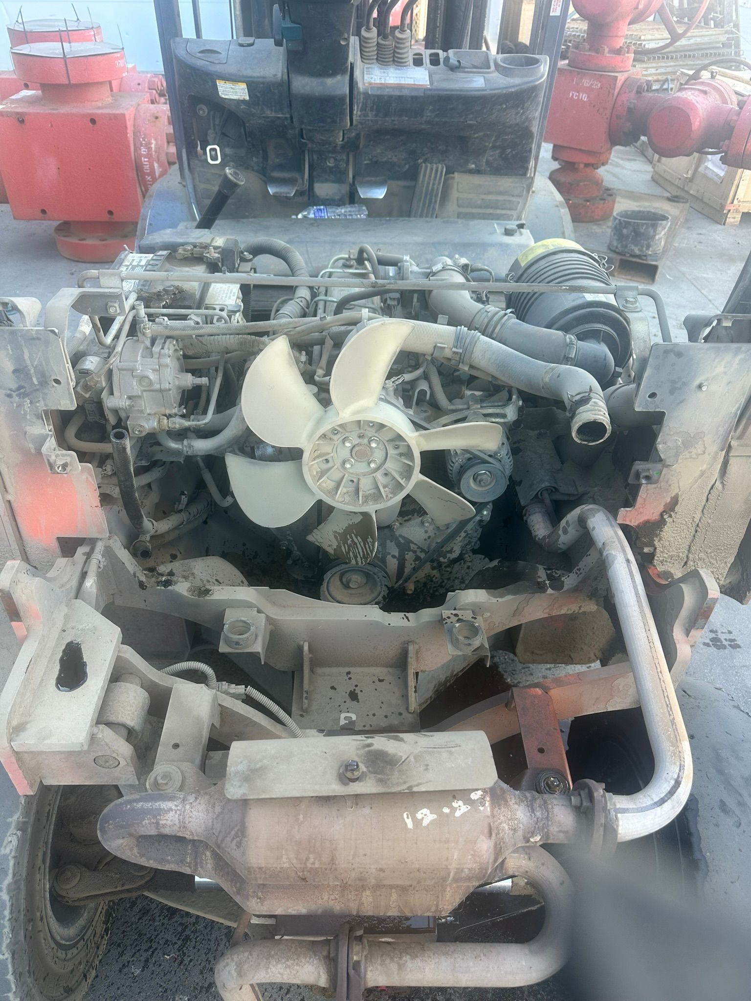 Engine of a vehicle with a fan, pipes, and other components visible.