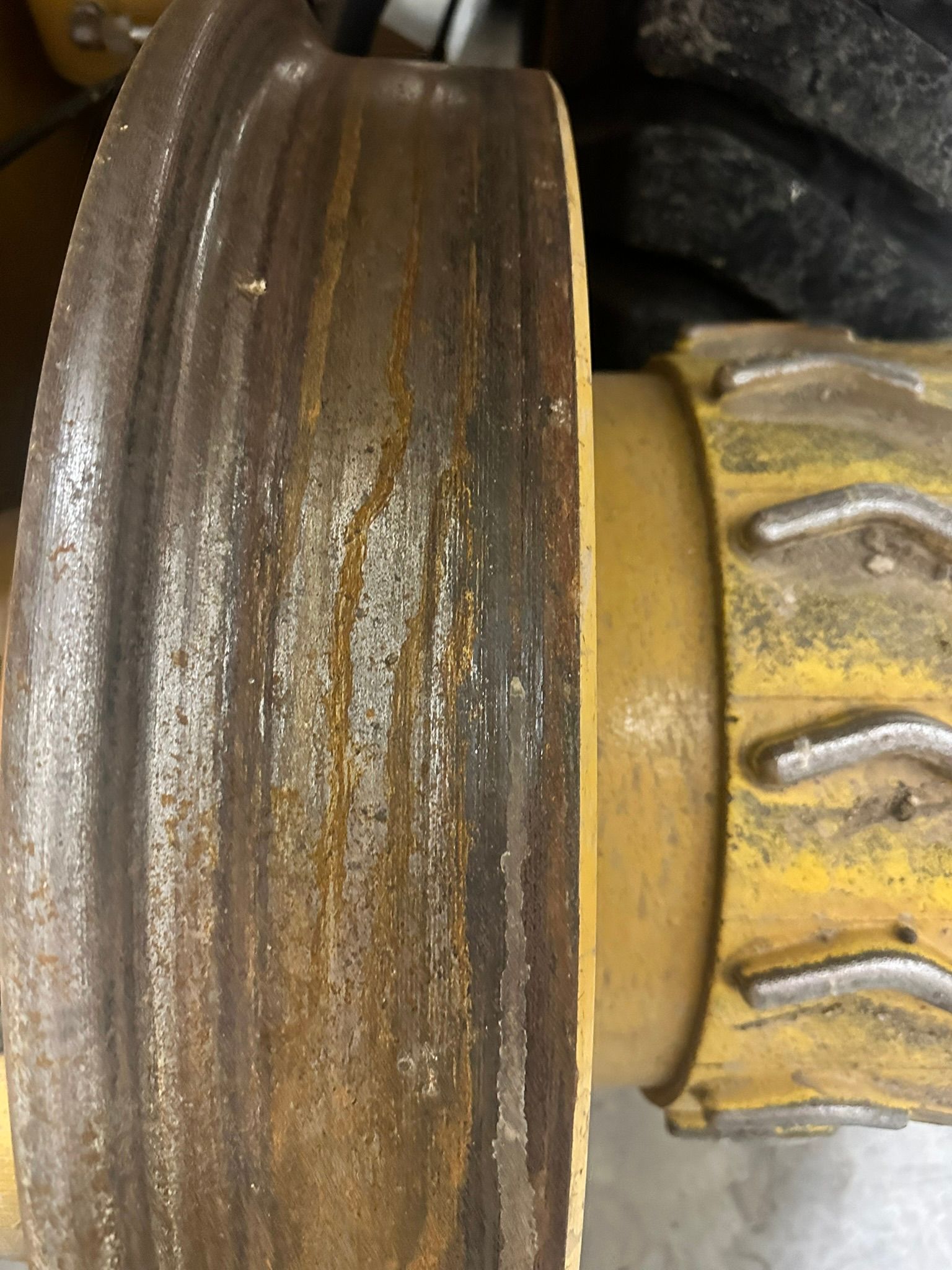 Rusty, yellow metal track wheel detail.