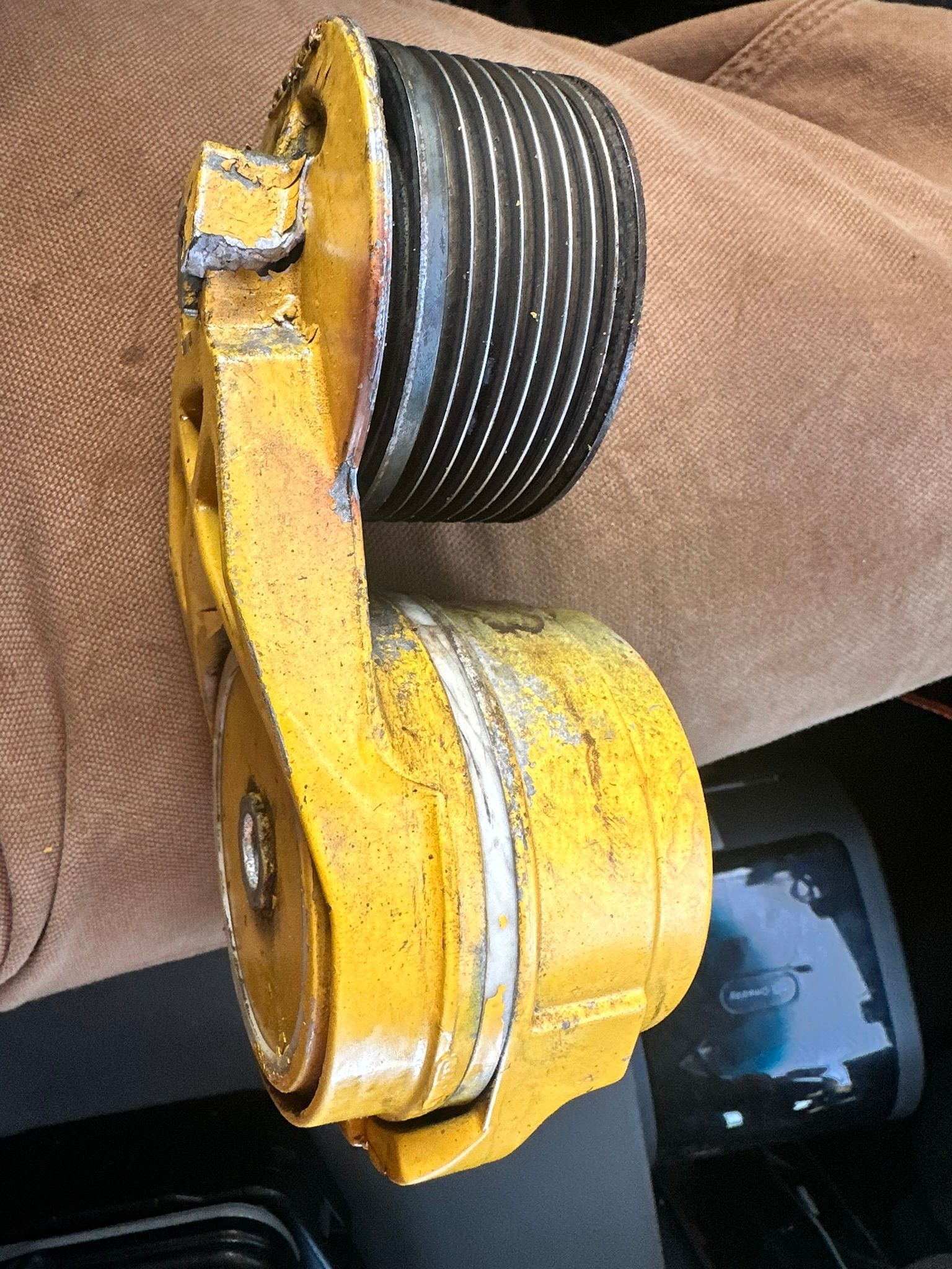 Yellow and black serpentine belt tensioner.