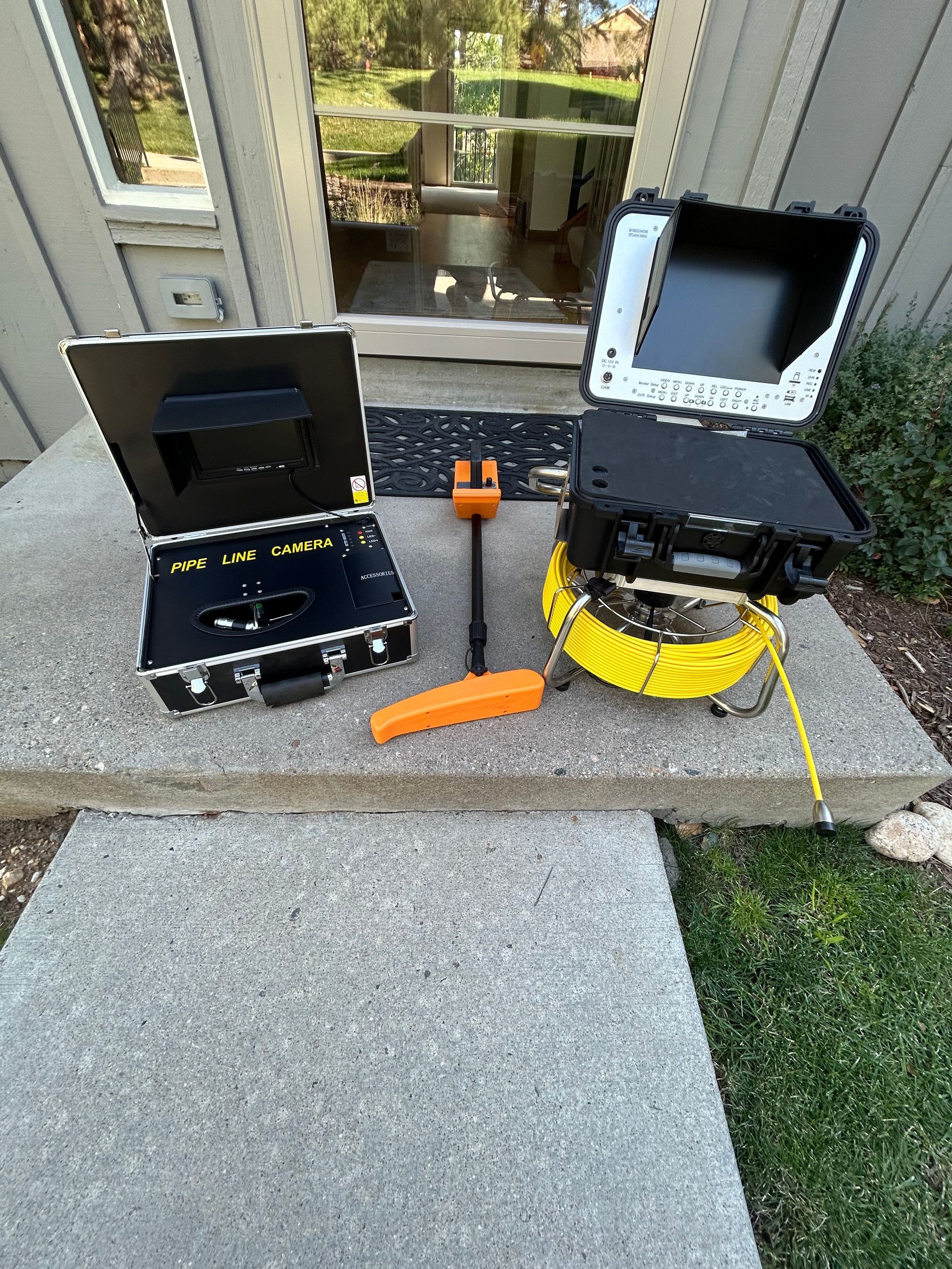 A couple of cameras are sitting on a sidewalk in front of a house.