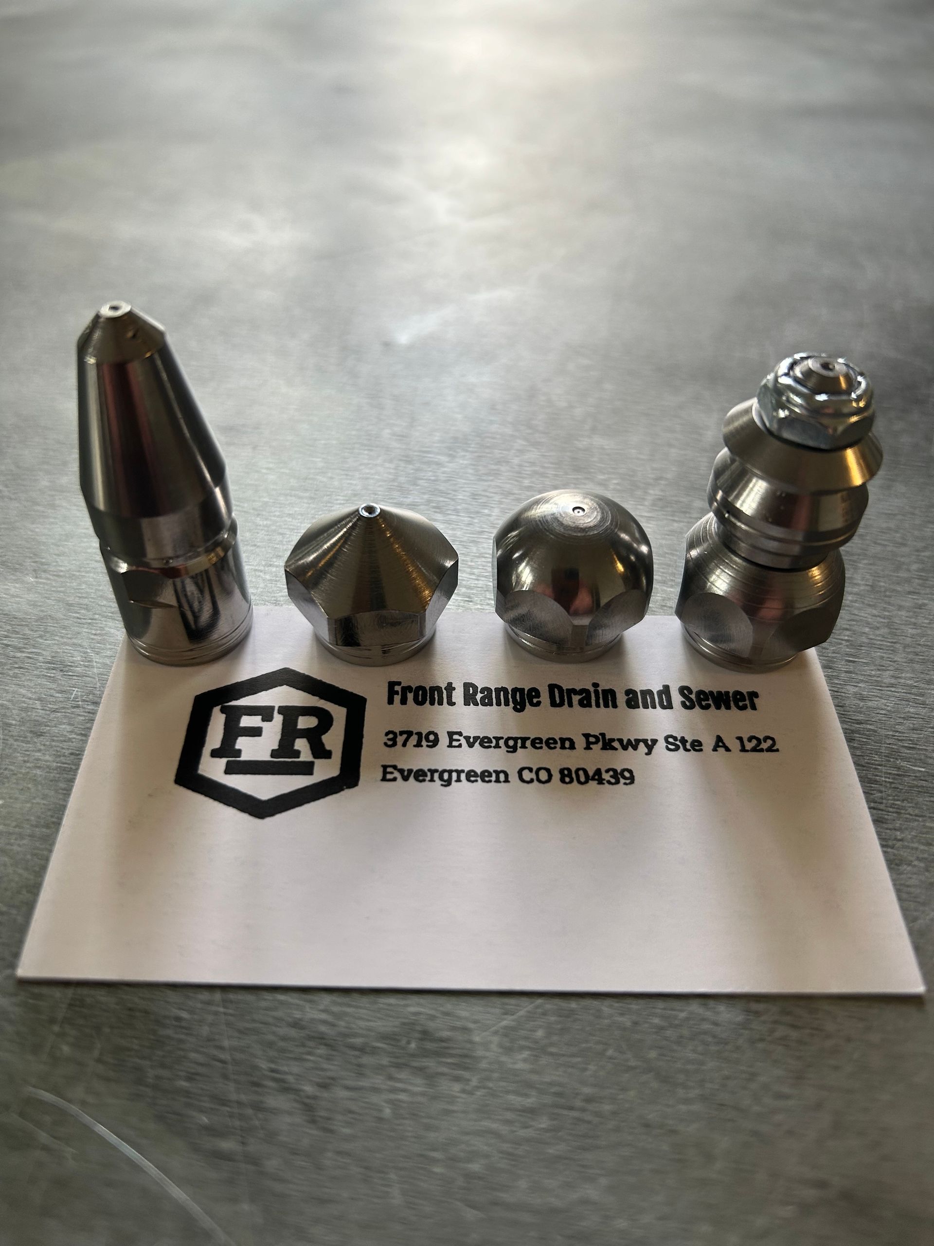 Four different types of nozzles are sitting on top of a business card.