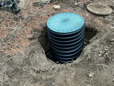 A stack of plastic pipes sitting in a hole in the ground.
