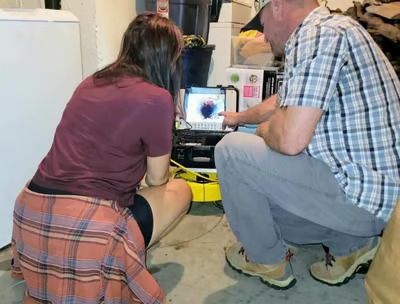 A man and a woman are looking at a computer screen.