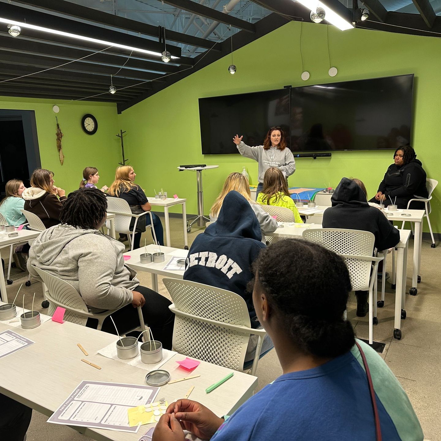 A Courageous Voice / Founder & CEO Amy Ever teaching a group of students in a classroom setting with chairs and desks. 