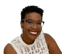 Smiling person with glasses in a white lace top against a white background