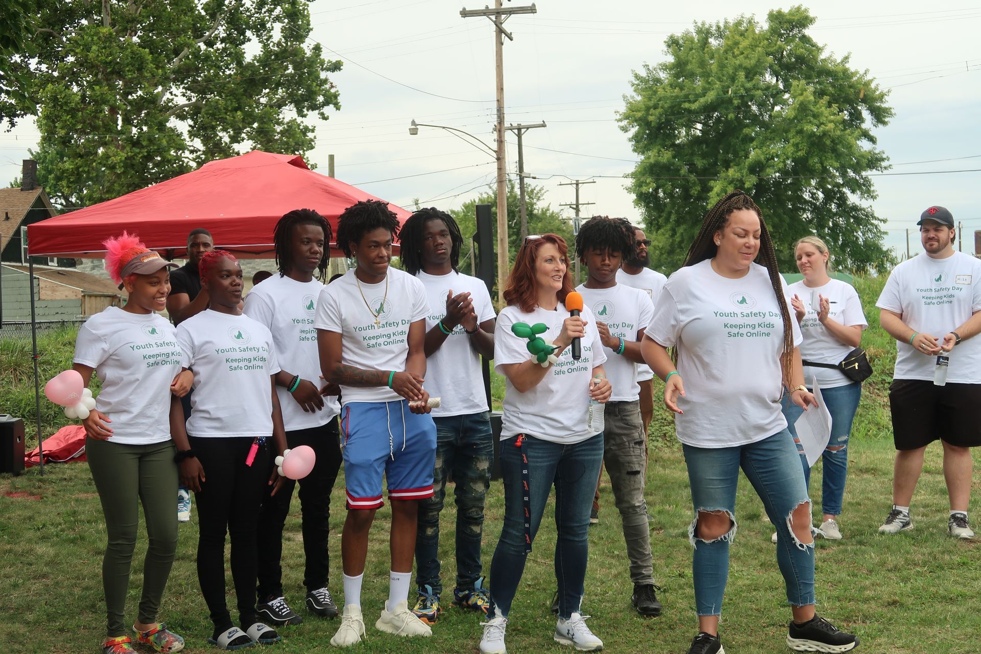 A group of people are standing in a grassy field.