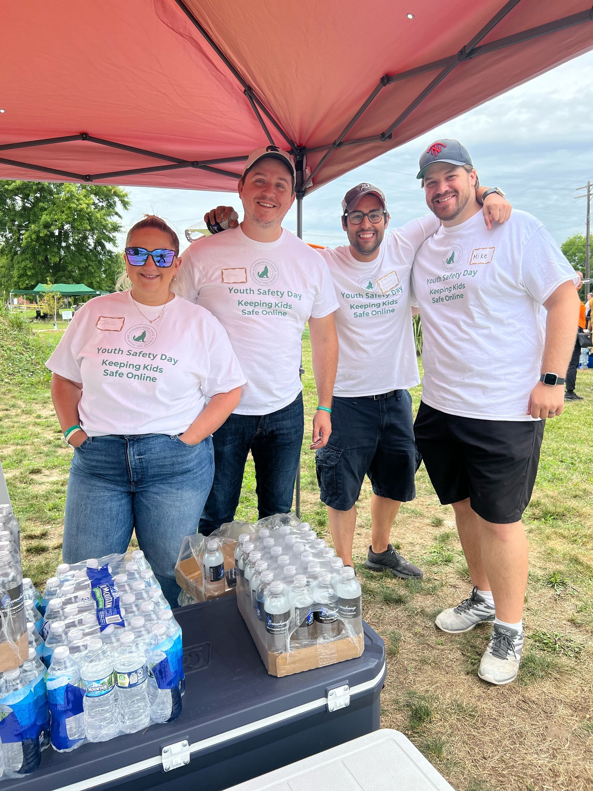 A group of people are posing for a picture under a tent.