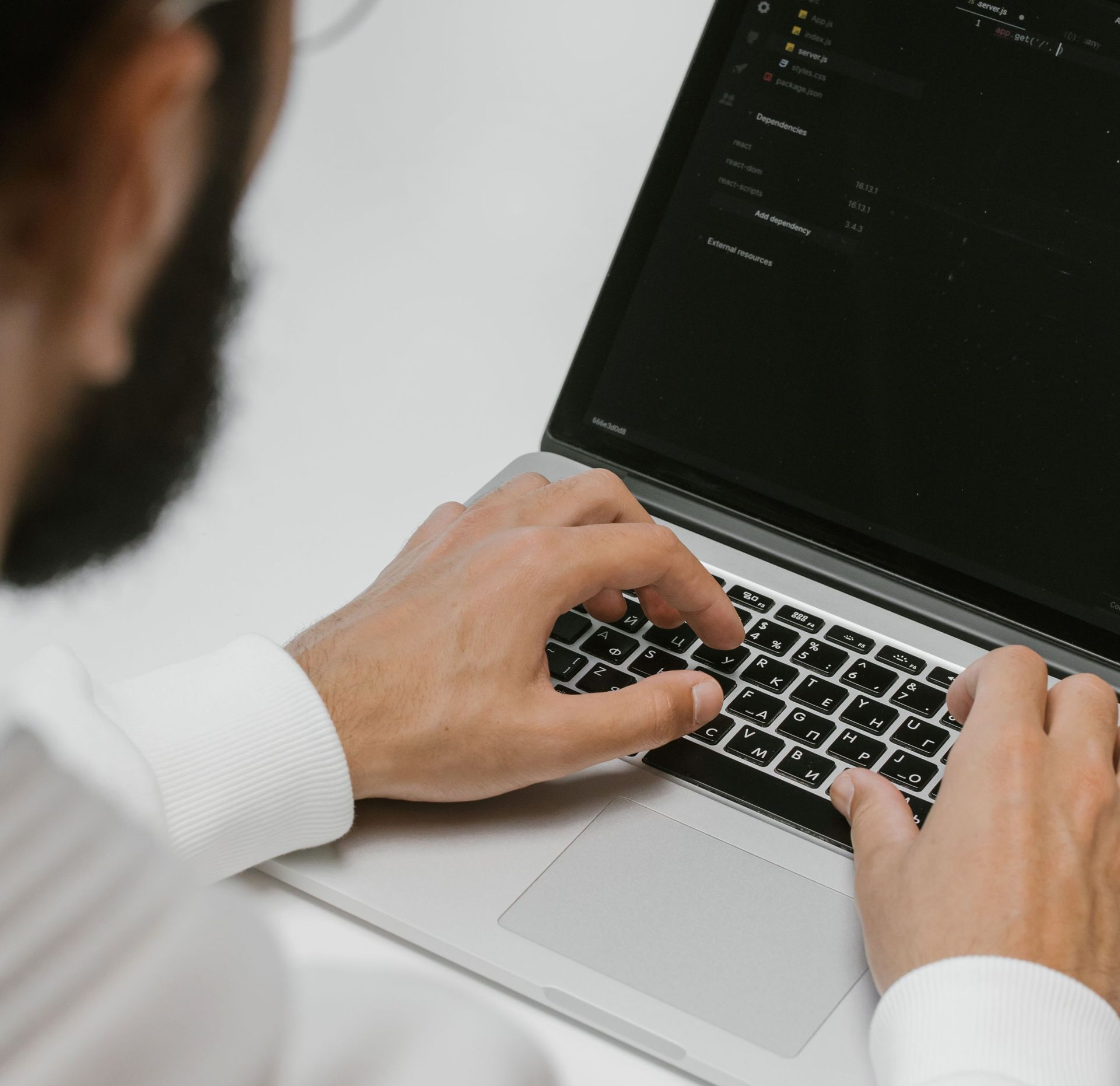 Hands typing on a laptop with code on the screen