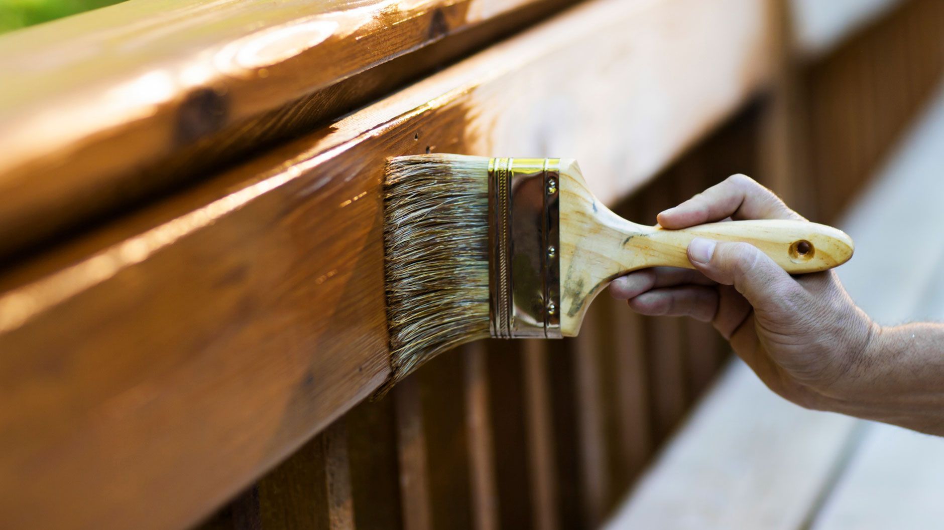 A man is painting a window on the side of a house