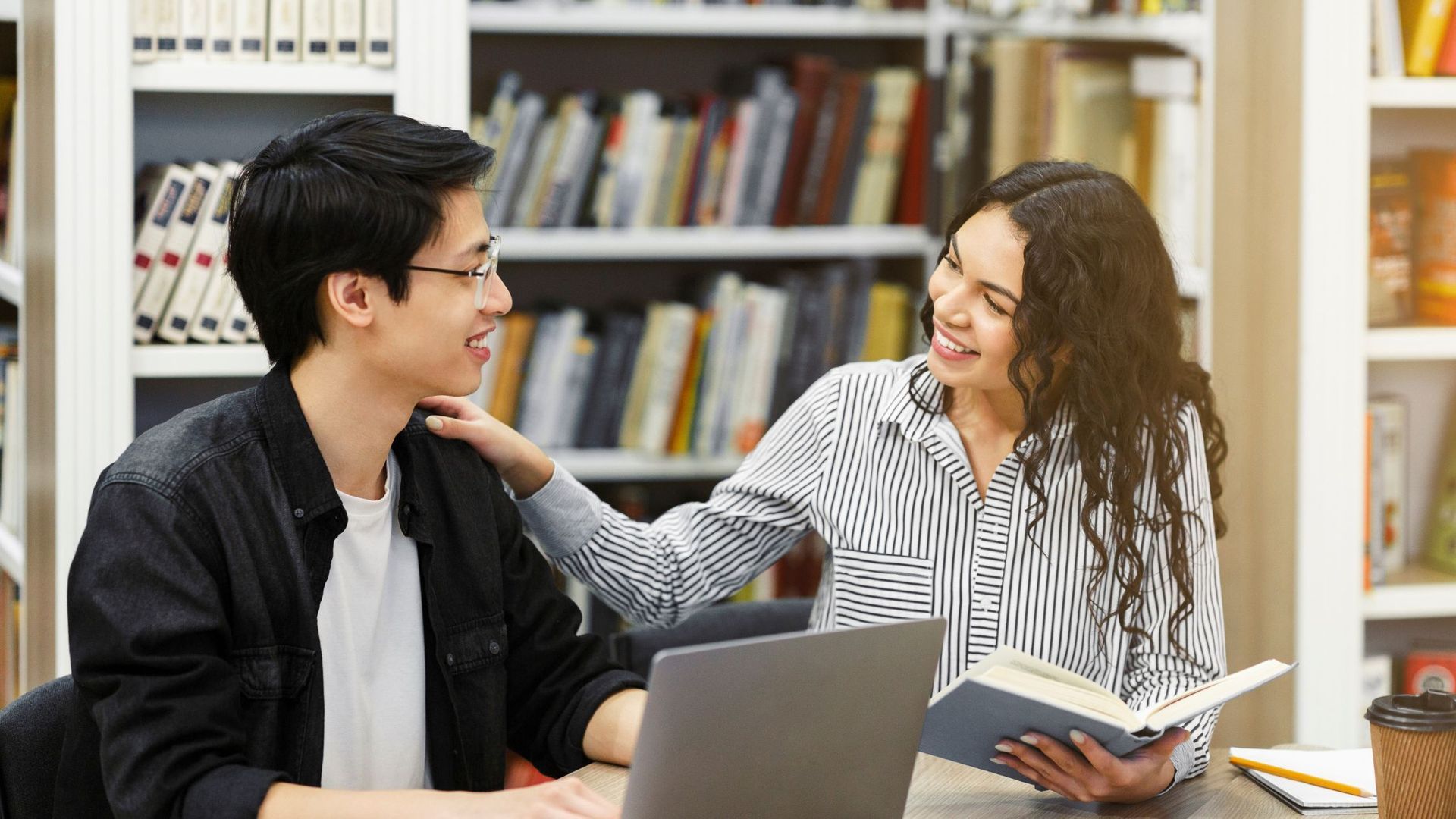 An independent educational consultant sitting next to a child giving them encouraging advice