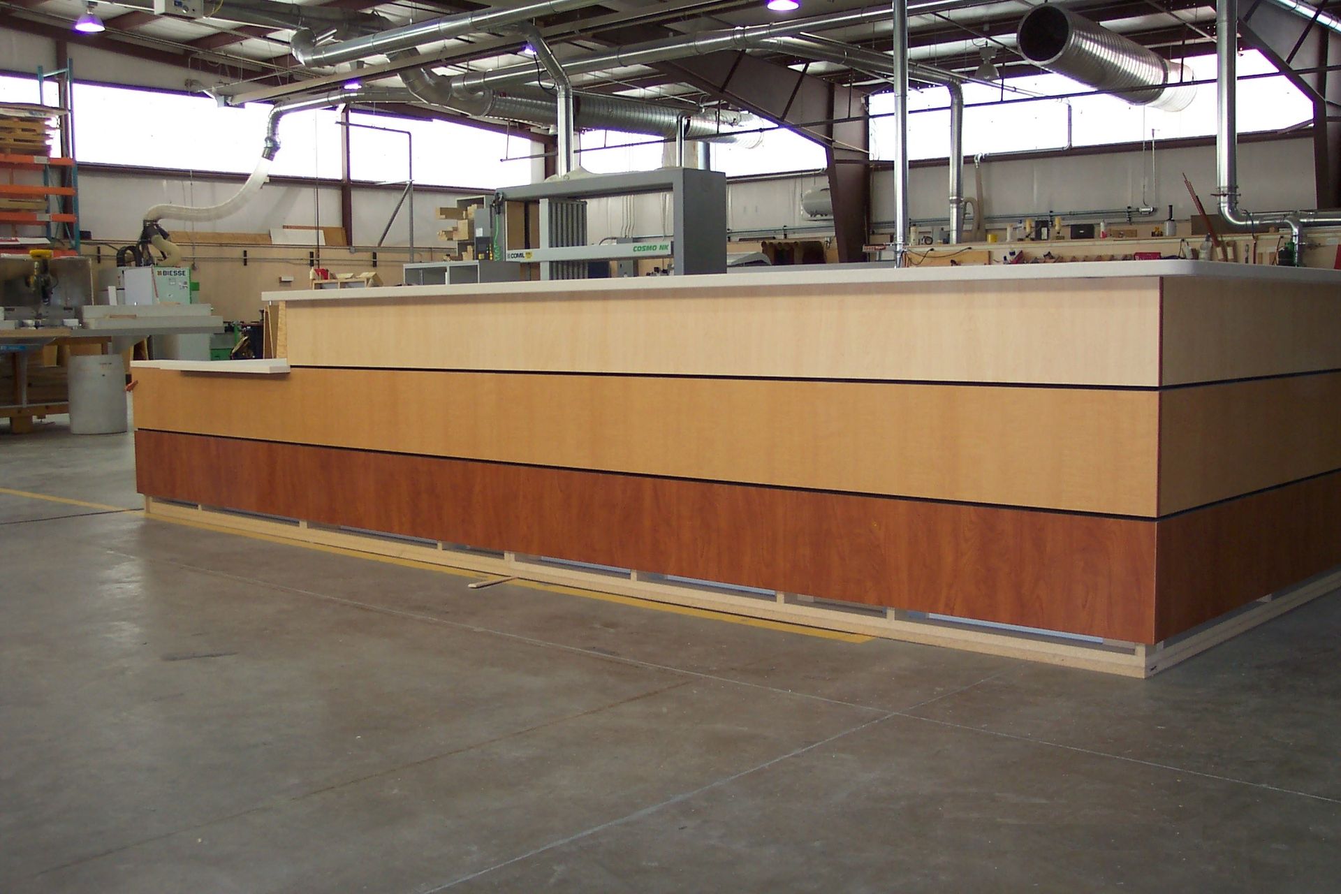 A large wooden counter in a warehouse with a white counter top