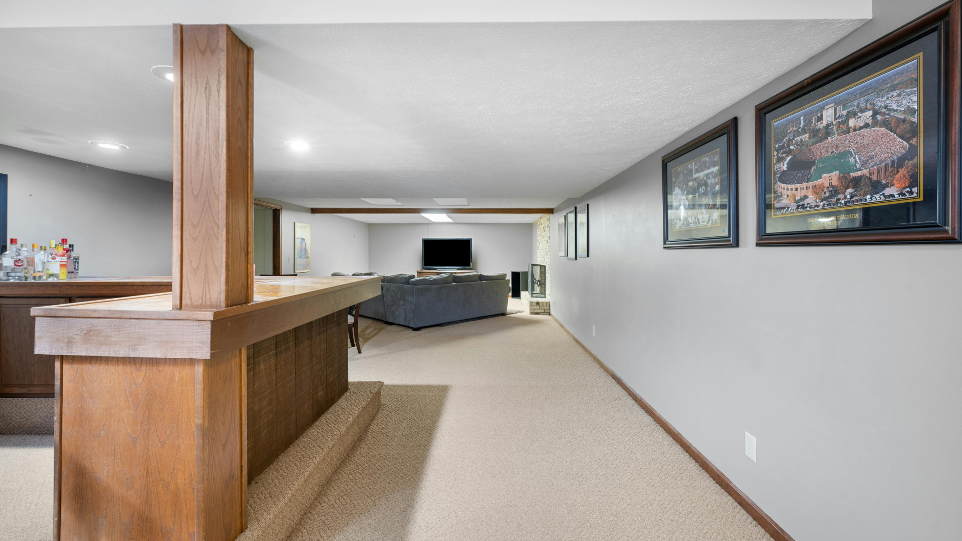 A basement with a bar , couch , and television.