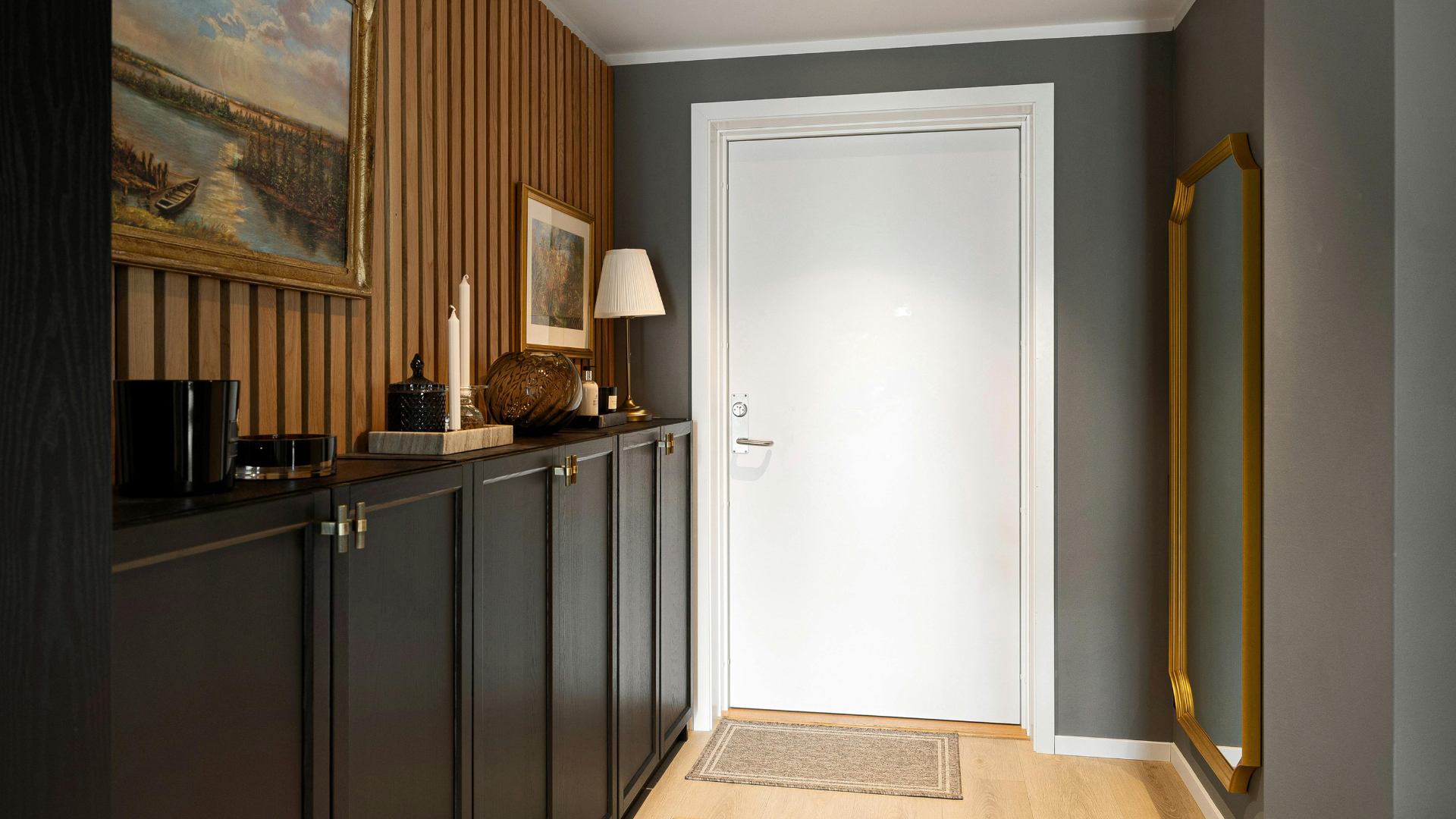 A hallway with a white door and a mirror.