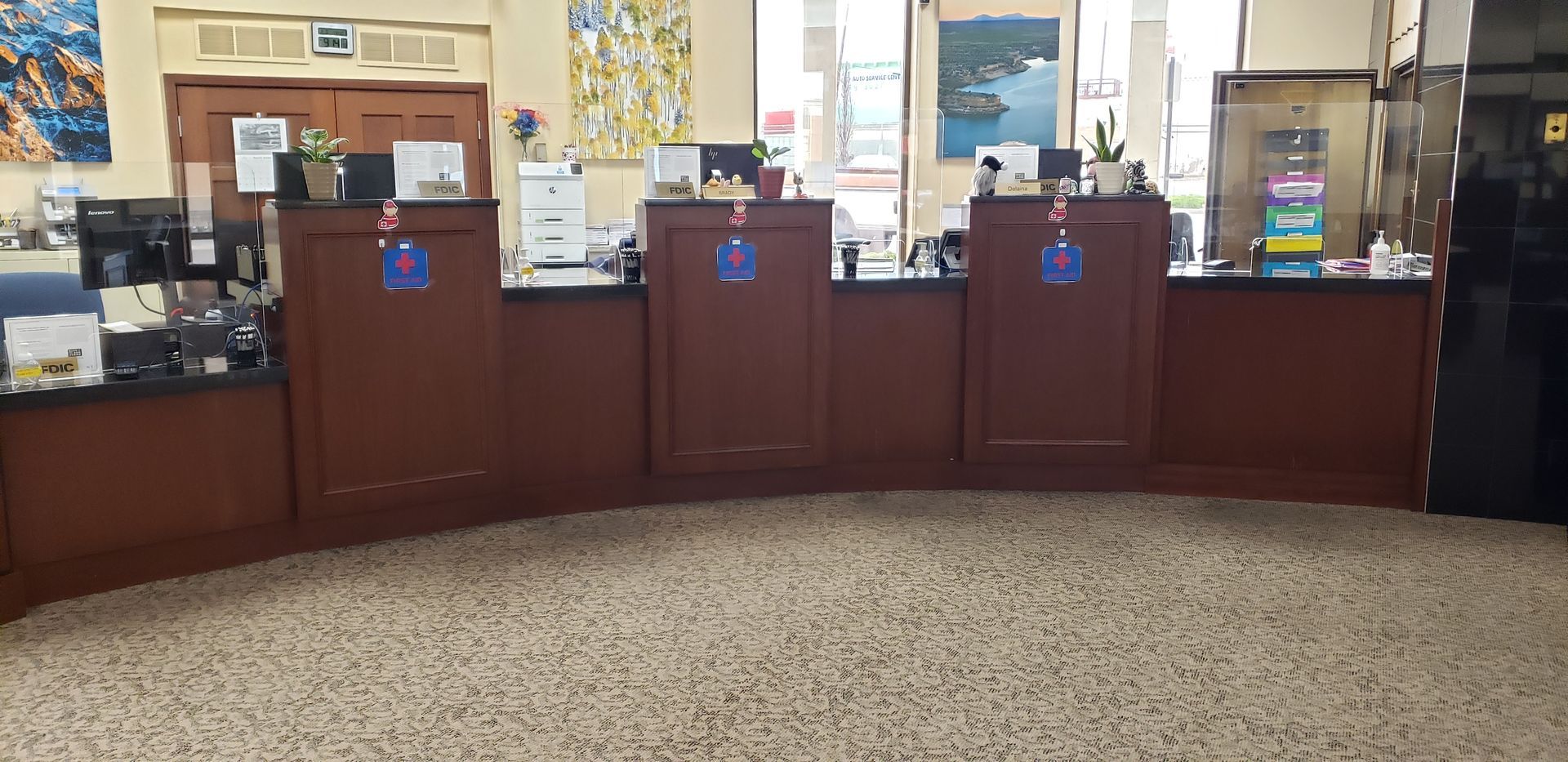 A bank with a lot of counters and a carpeted floor.