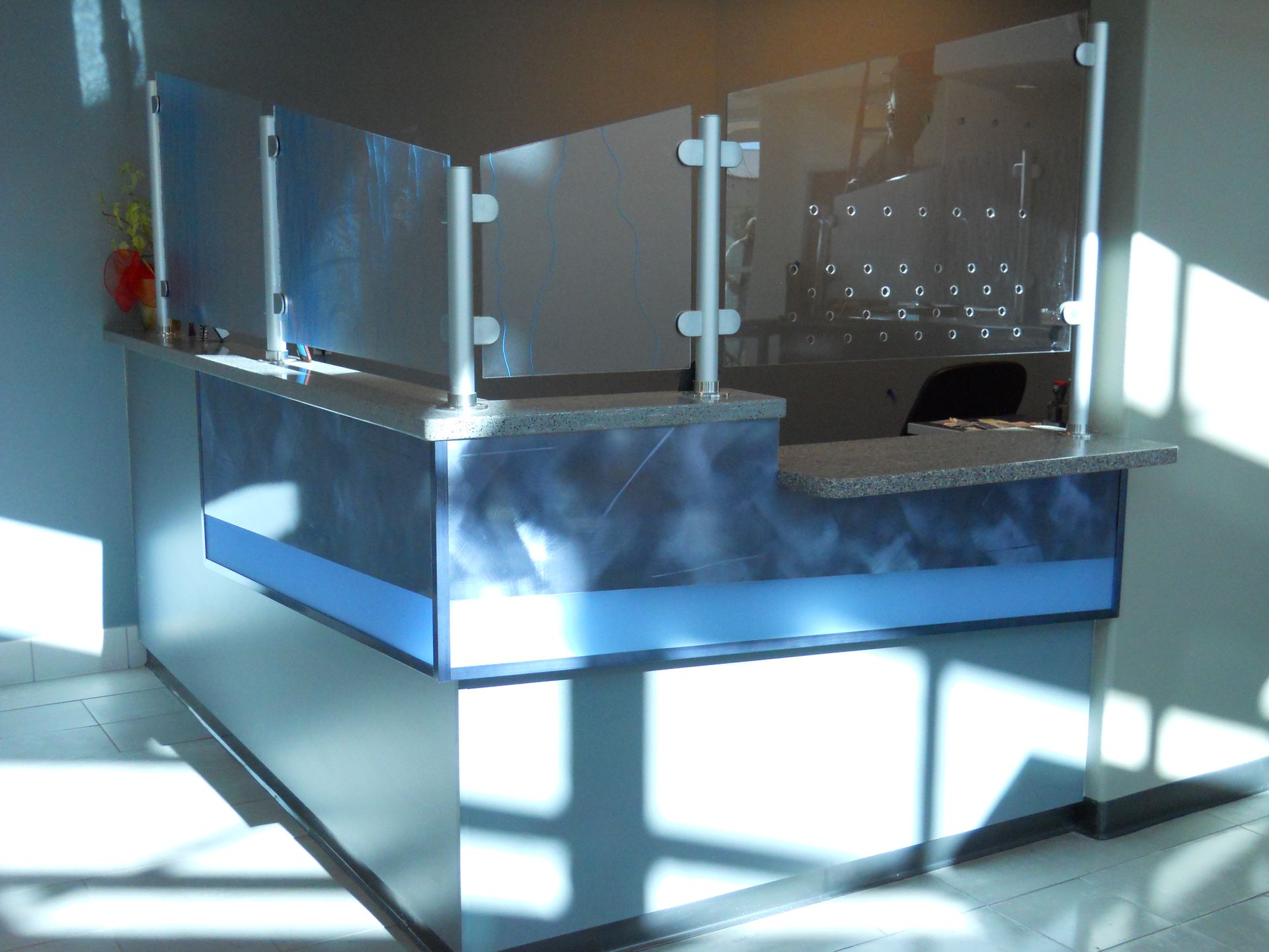 A blue and white reception desk with a glass divider