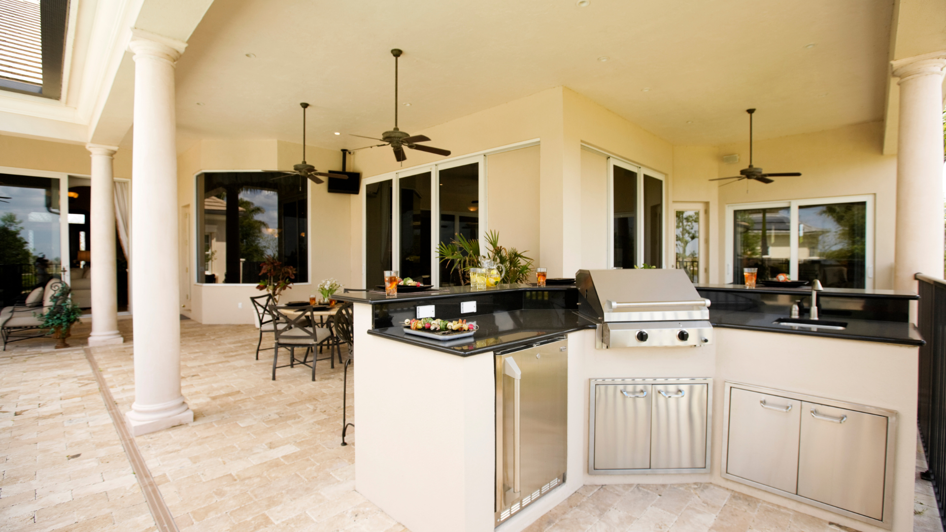 A kitchen with a grill and a dining area in the background.