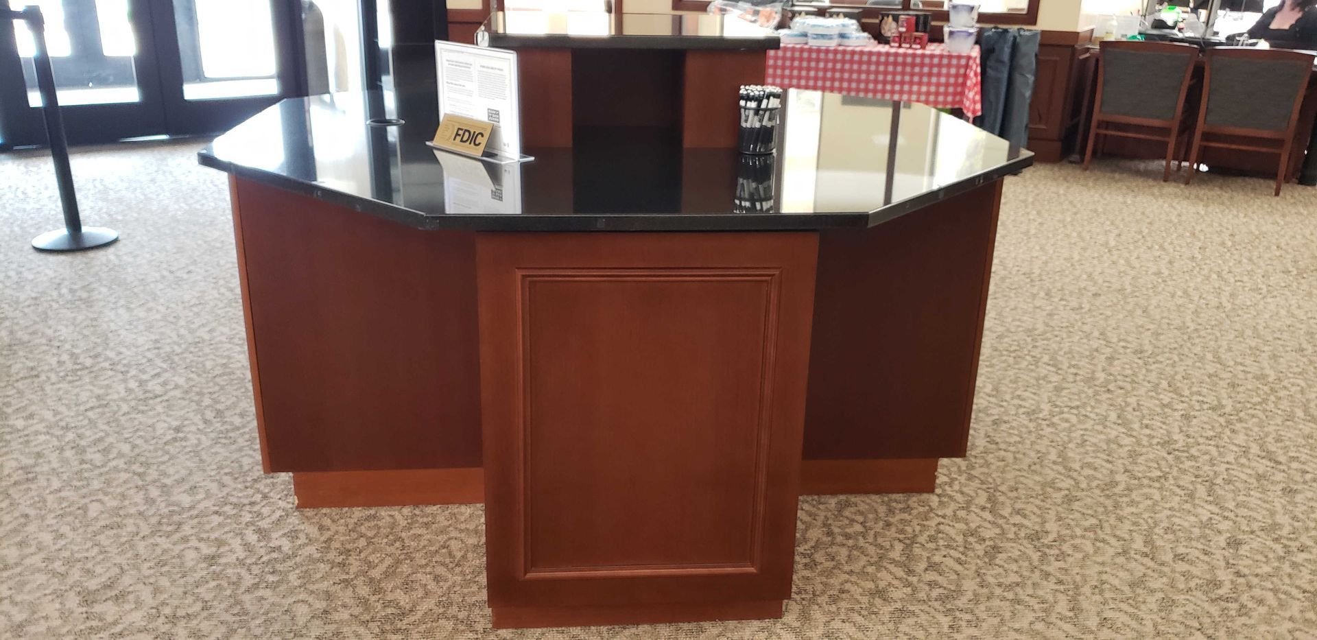 A large wooden table with a black granite top in a room.