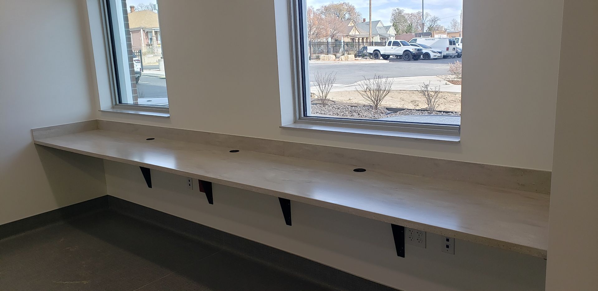 An empty room with a window and a long counter.