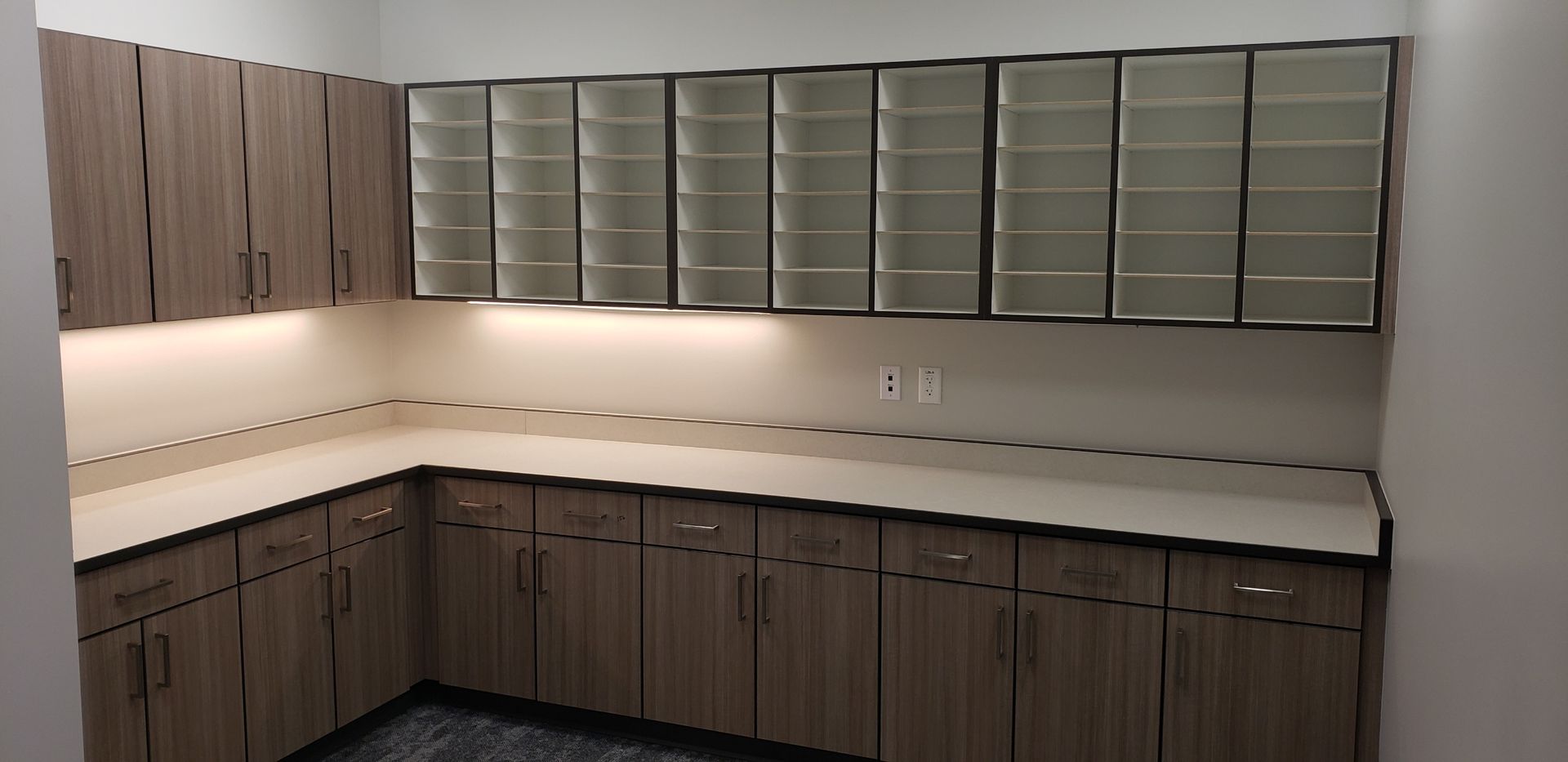 A kitchen with wooden cabinets and white counter tops.