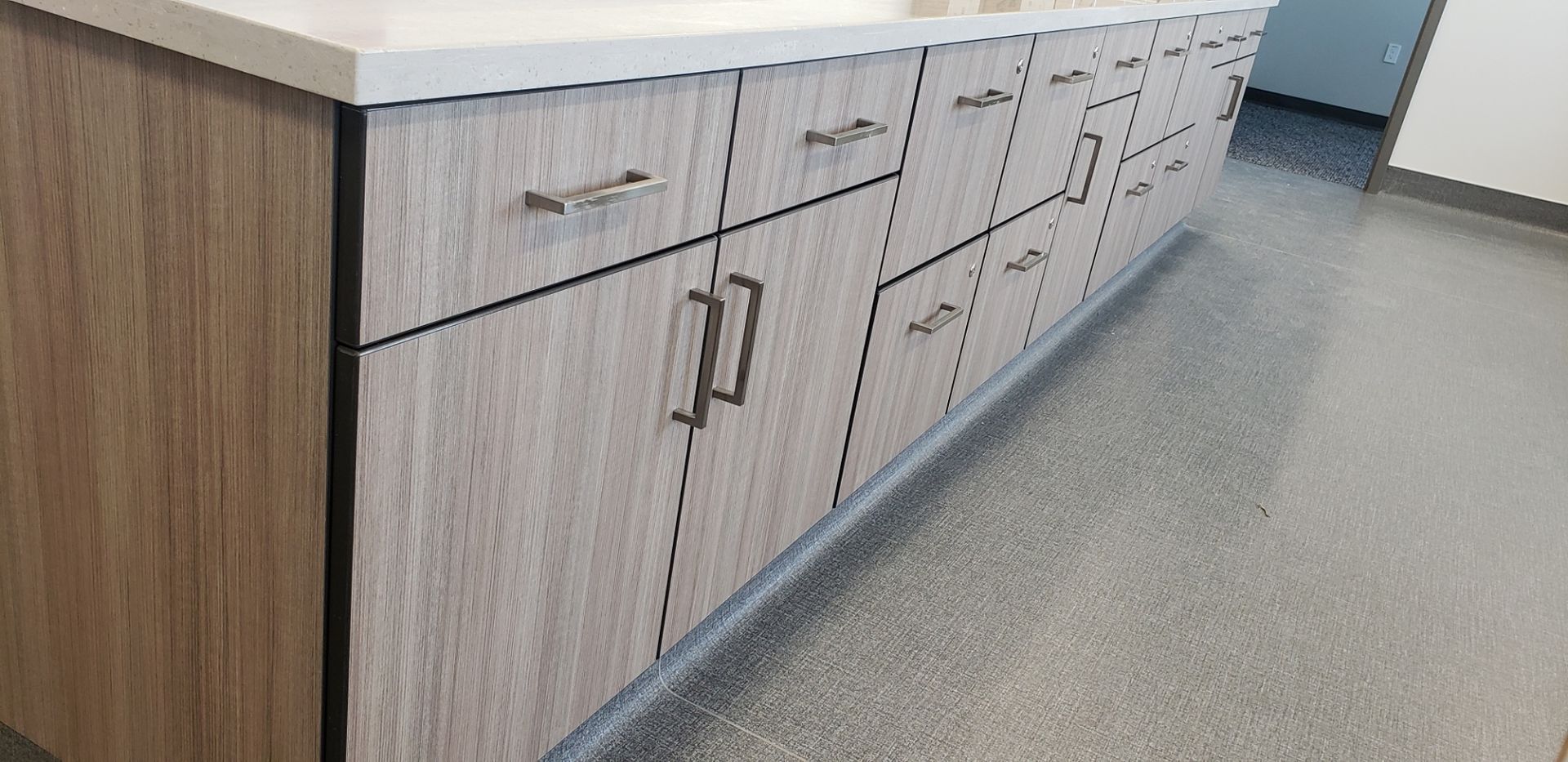 A kitchen with a lot of cabinets and drawers and a counter top.