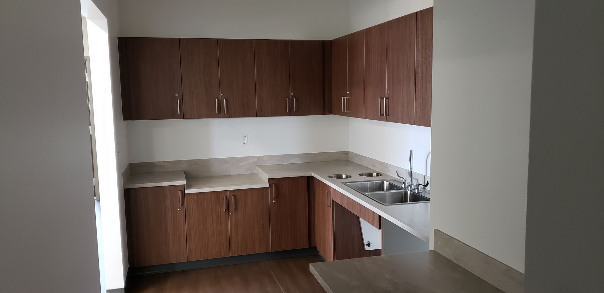 An empty kitchen with wooden cabinets and a sink