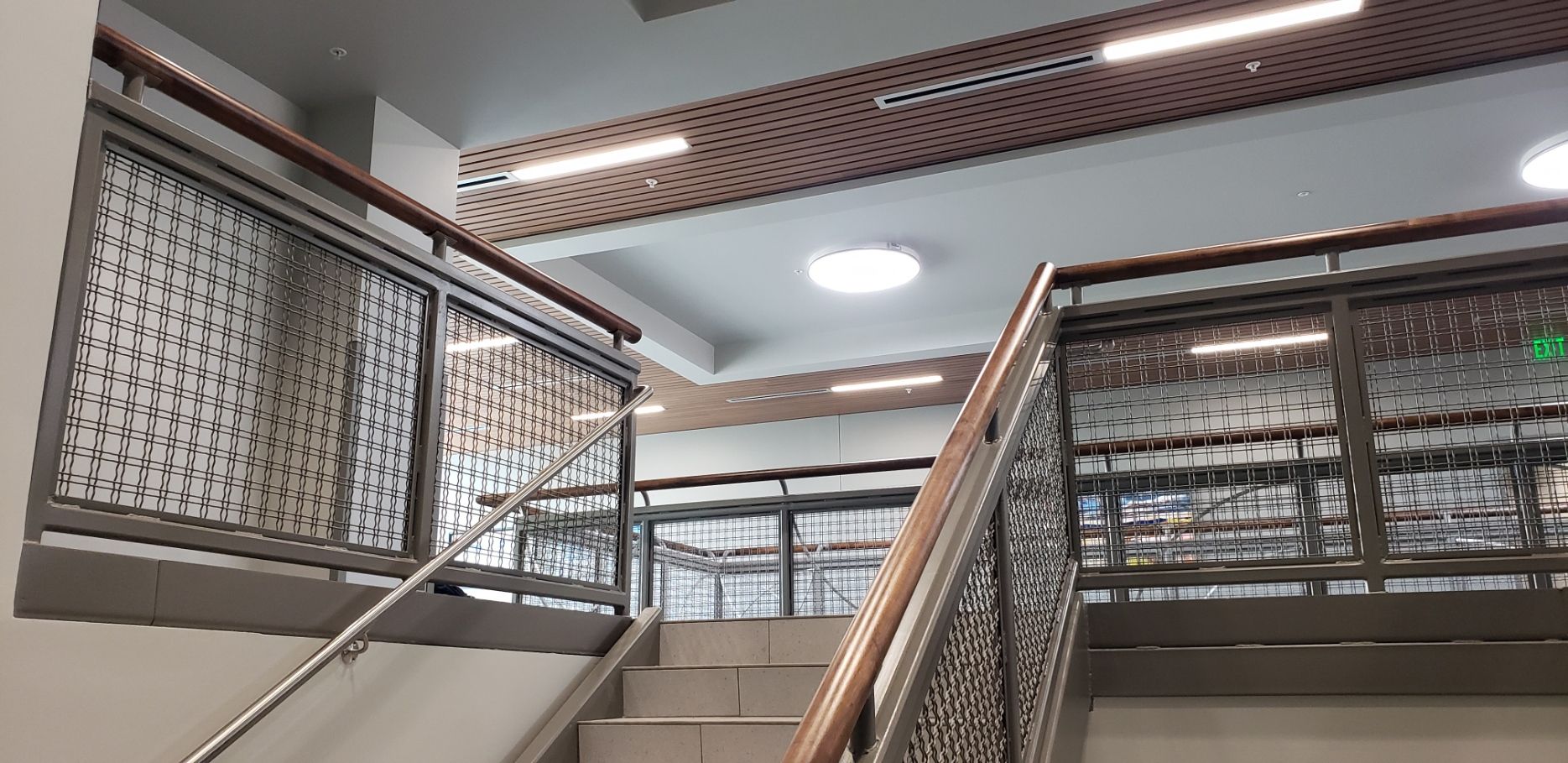 A staircase with a metal railing and a wooden handrail in a building.