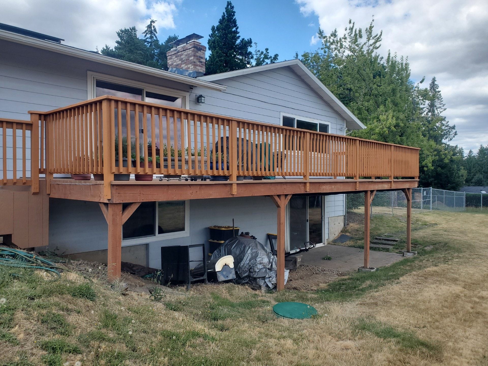 A large wooden deck is sitting on the back of a house.