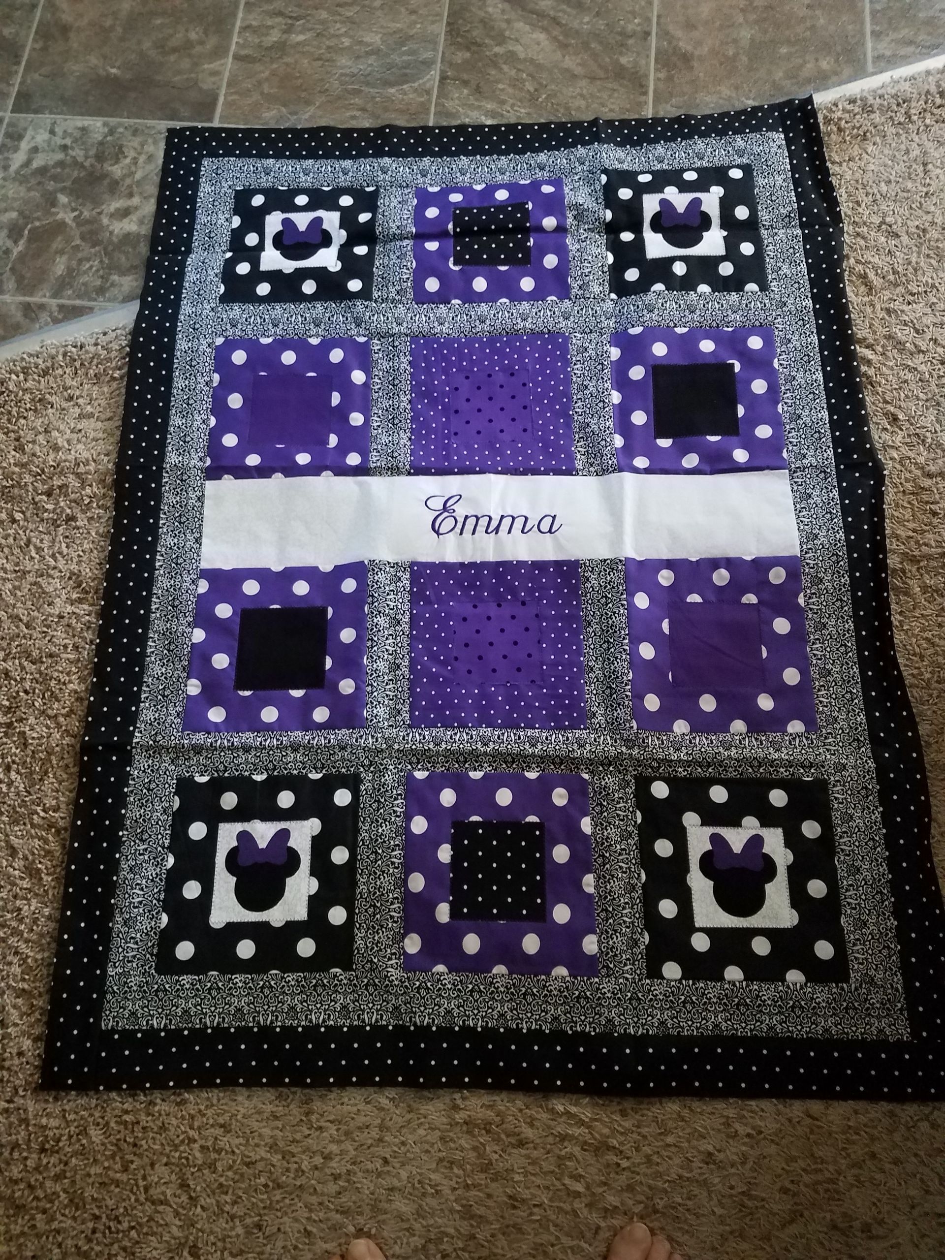 A purple and black quilt with the name emma on it