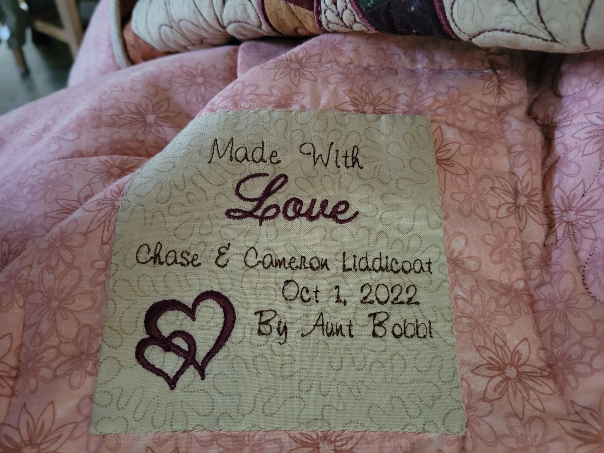 A pink blanket with a piece of fabric that says made with love