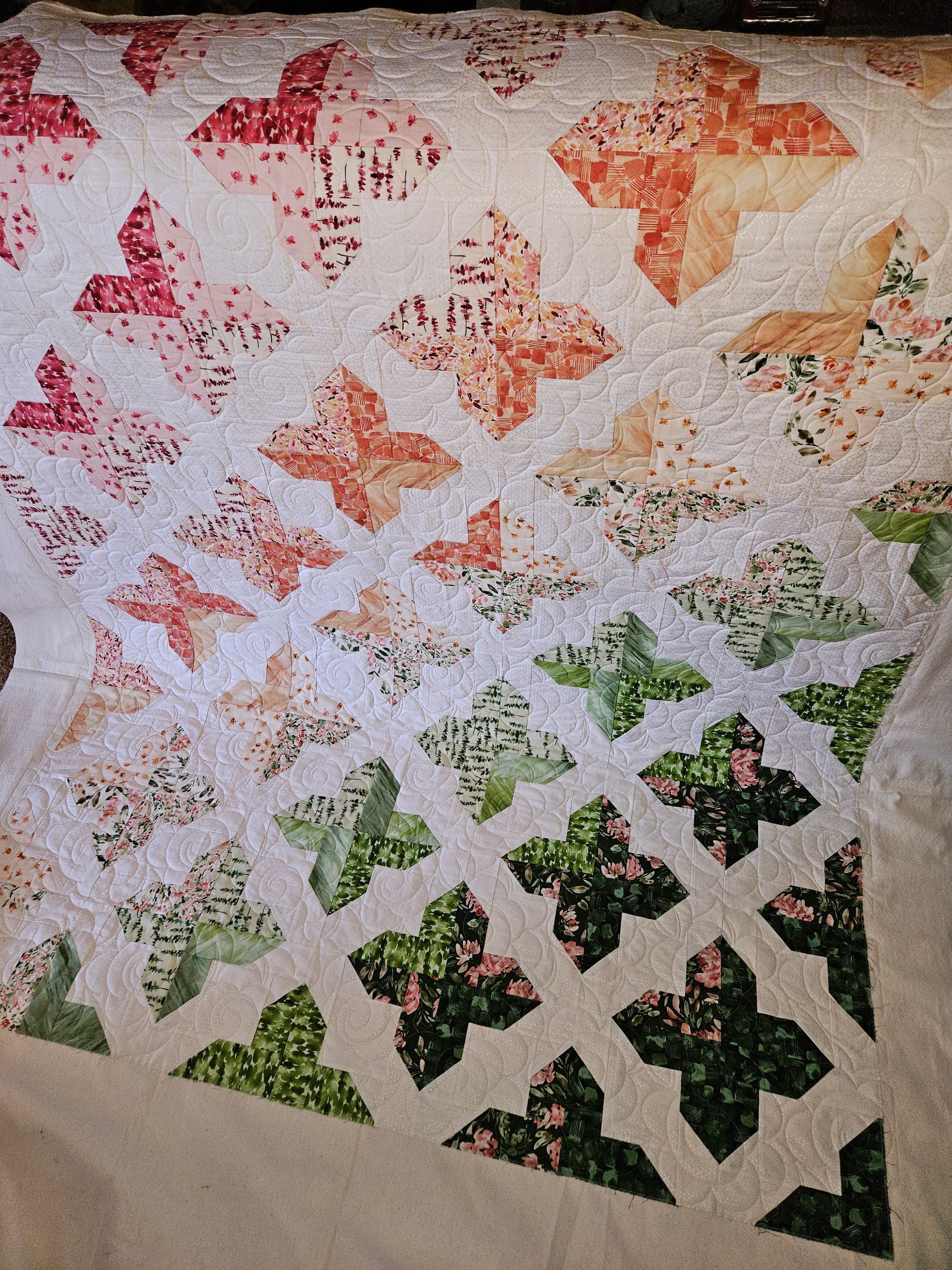 A quilt with butterflies on it is laying on a bed