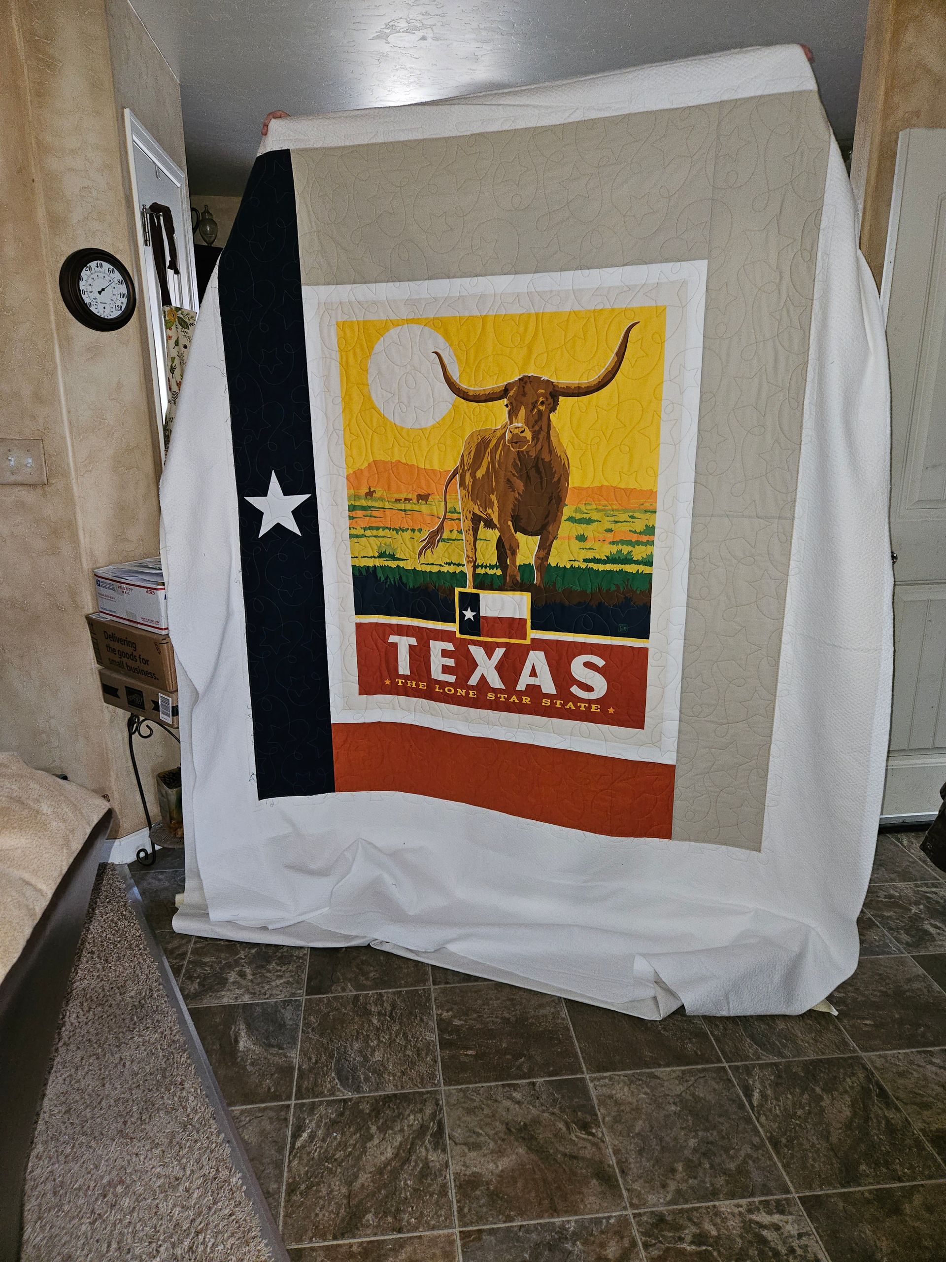 A blanket with a picture of a bull on it is hanging on a wall.