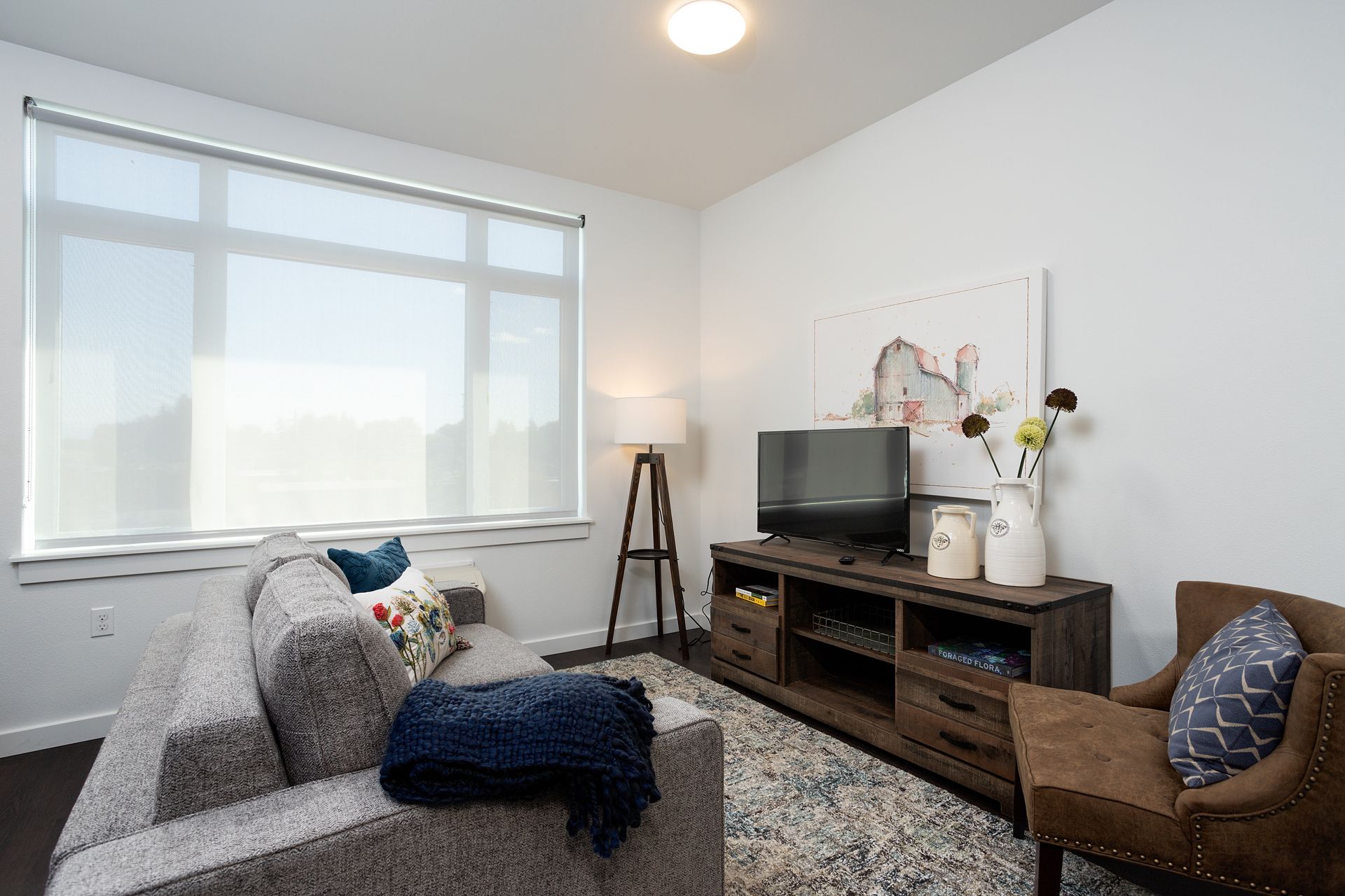 A living room with a couch , chair , and television.