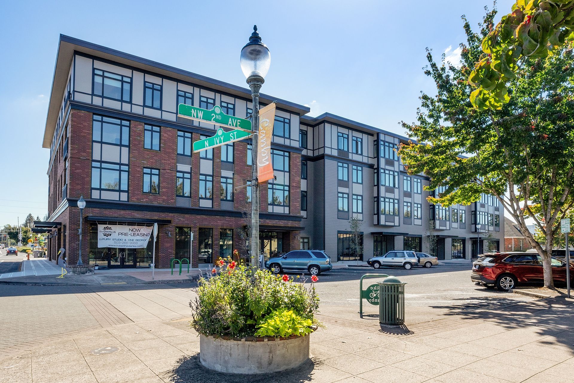 A large brick building with a green street sign in front of it.