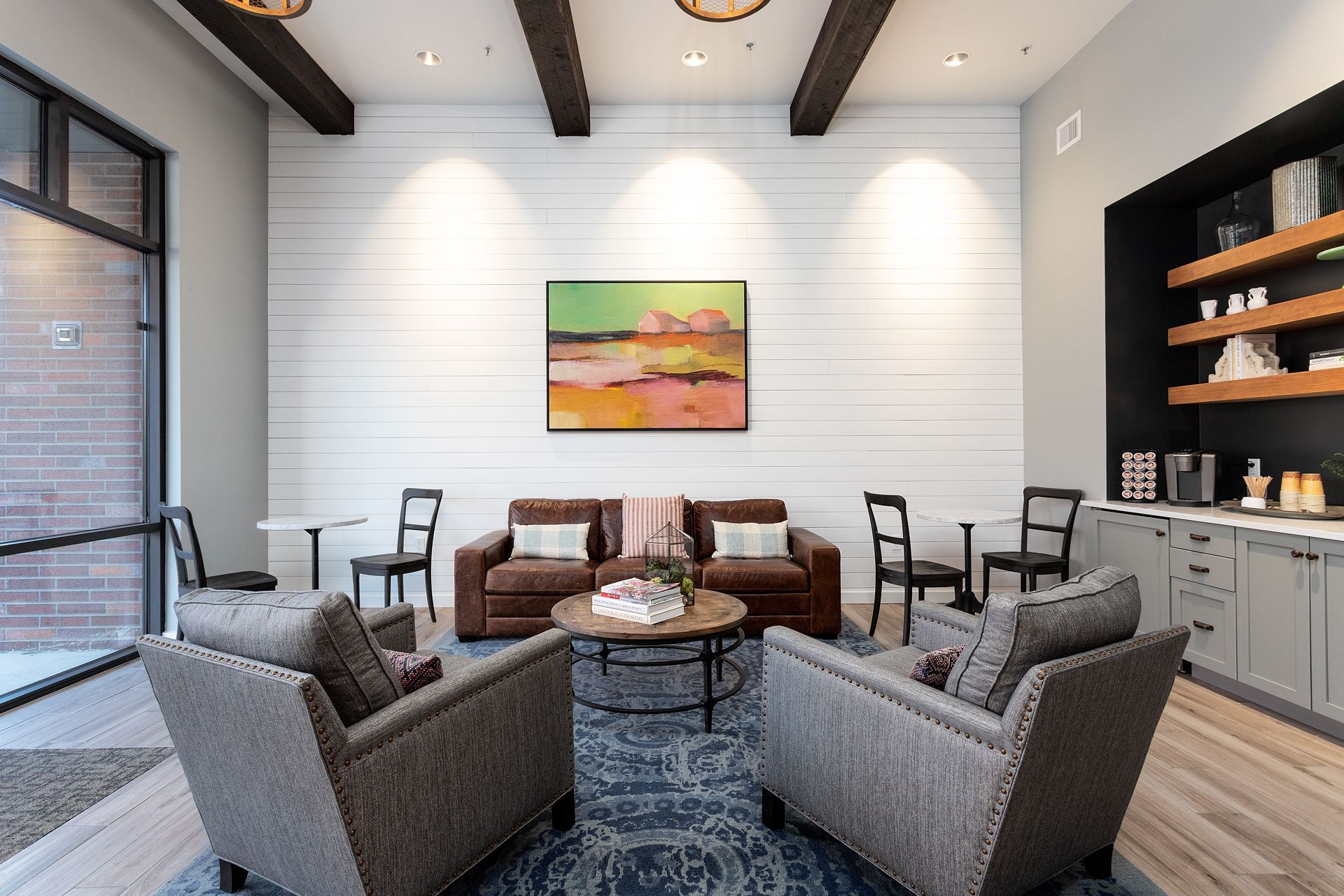 A living room filled with furniture and a painting on the wall.