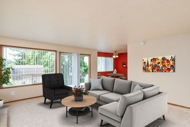 A kitchen and living room in a house with a ceiling fan.