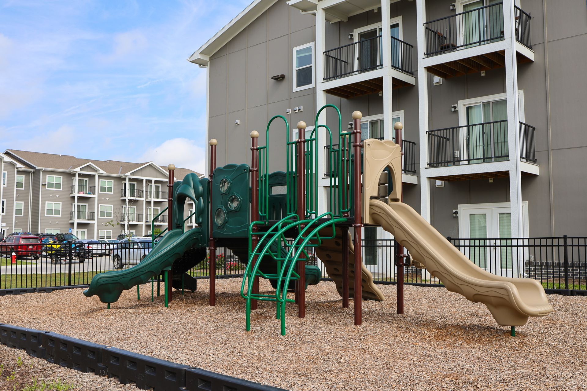 Lincoln, NE Affordable Apartments - Union at Middle Creek - Playground with Multi-Purpose Play Structure on Mulch, and Fence