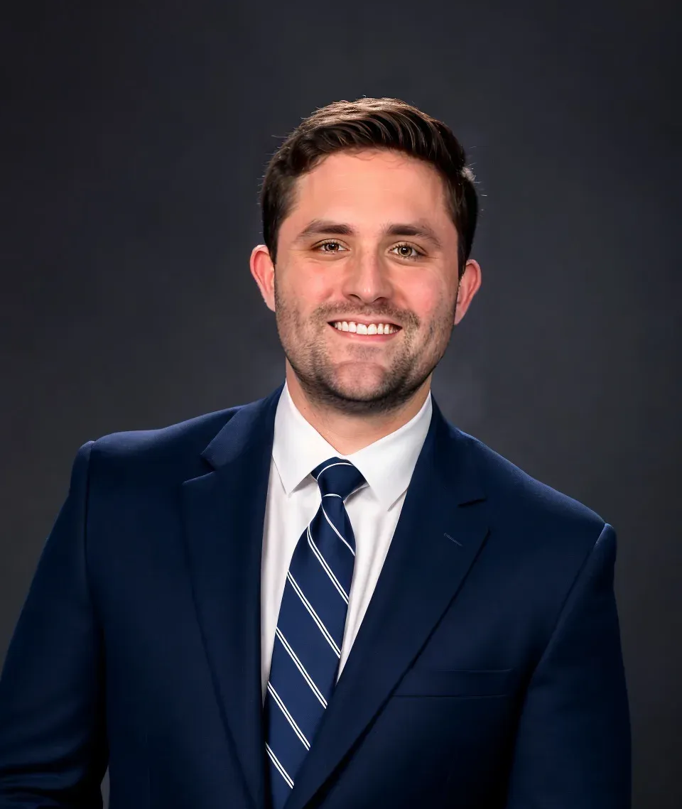 A man in a suit and tie is smiling for the camera.