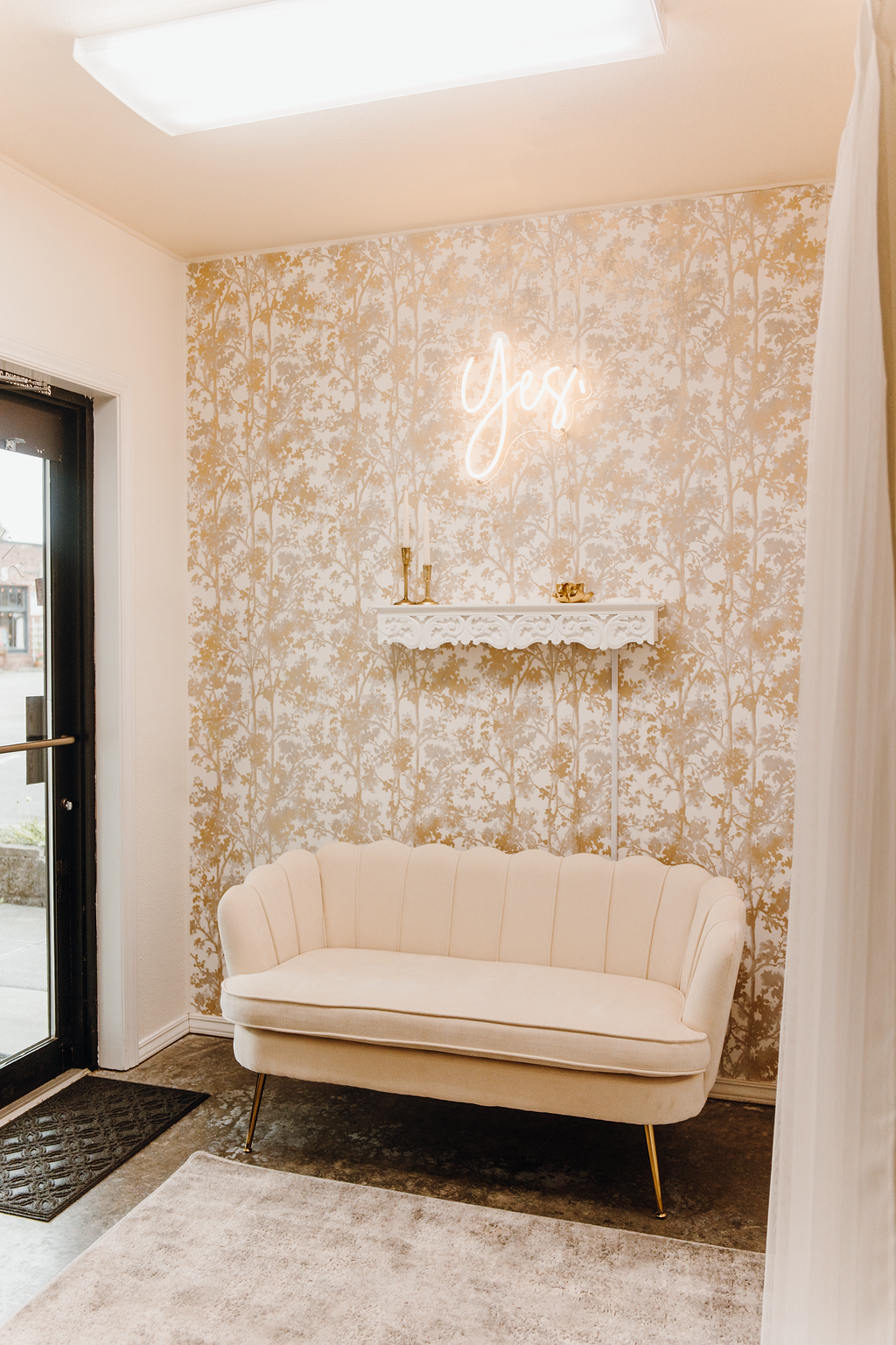 Cream-colored bench in front of a textured gold wall with a
